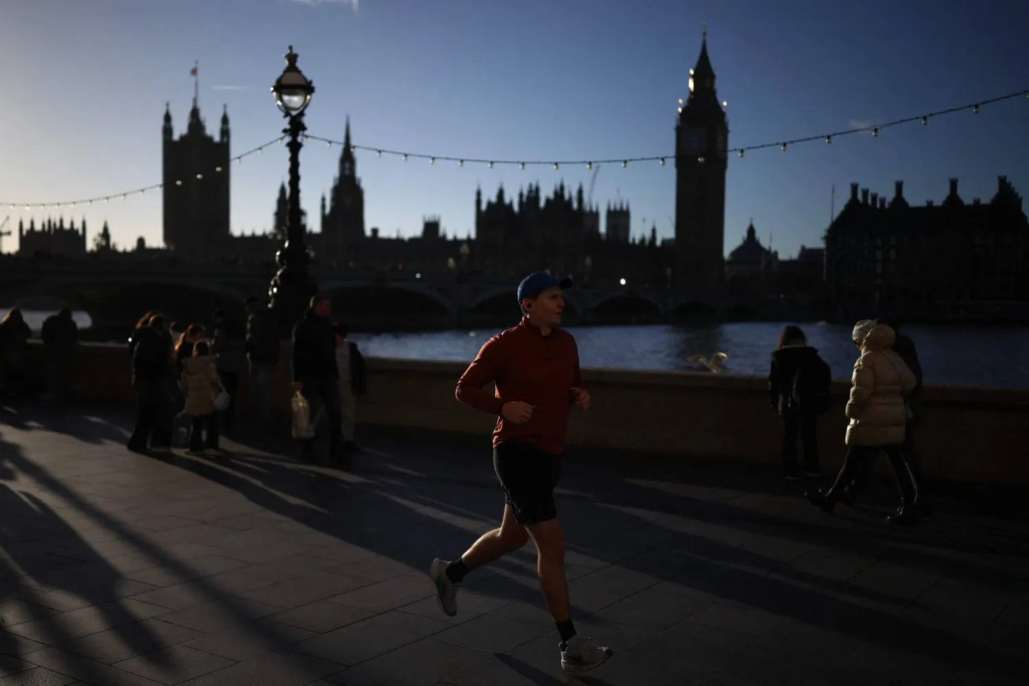 عدّاء يركض تحت أشعة الشمس في ظهيرة باردة بلندن (أ.ف.ب)