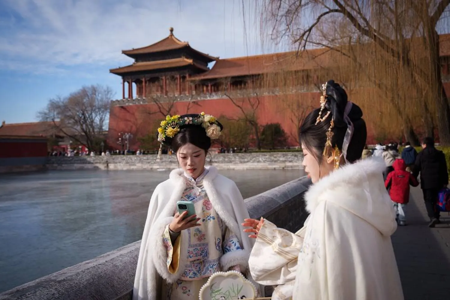  Chinese girls dressed in Qing Dynasty attire take pictures outside the Forbidden City in Beijing, China, Wednesday, Jan. 7, 2026. (AP) 