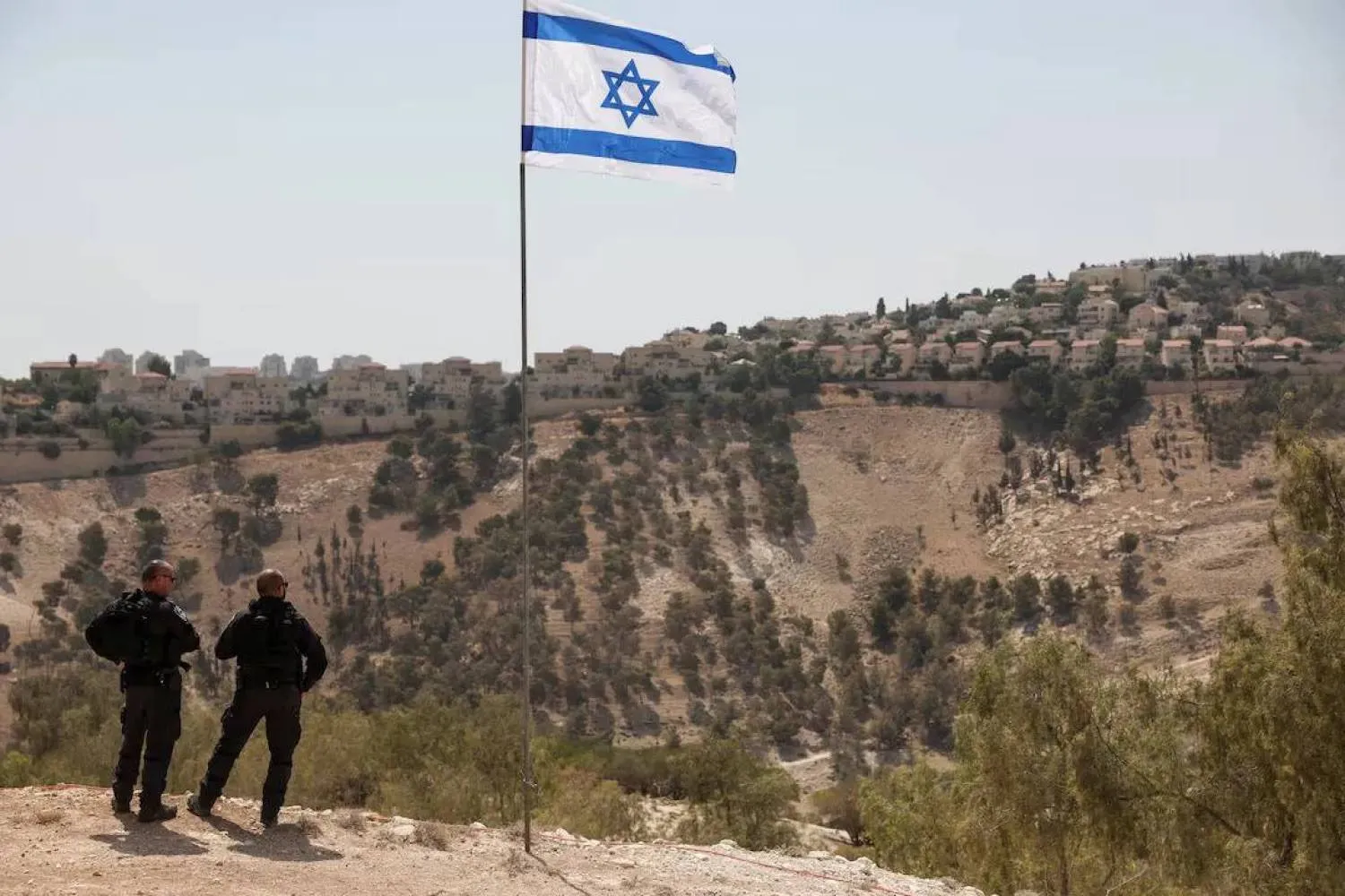 The Israeli flag, with part of the Israeli settlement of Ma’ale Adumim visible in the background in the occupied West Bank on August 14, 2025. (Reuters) 