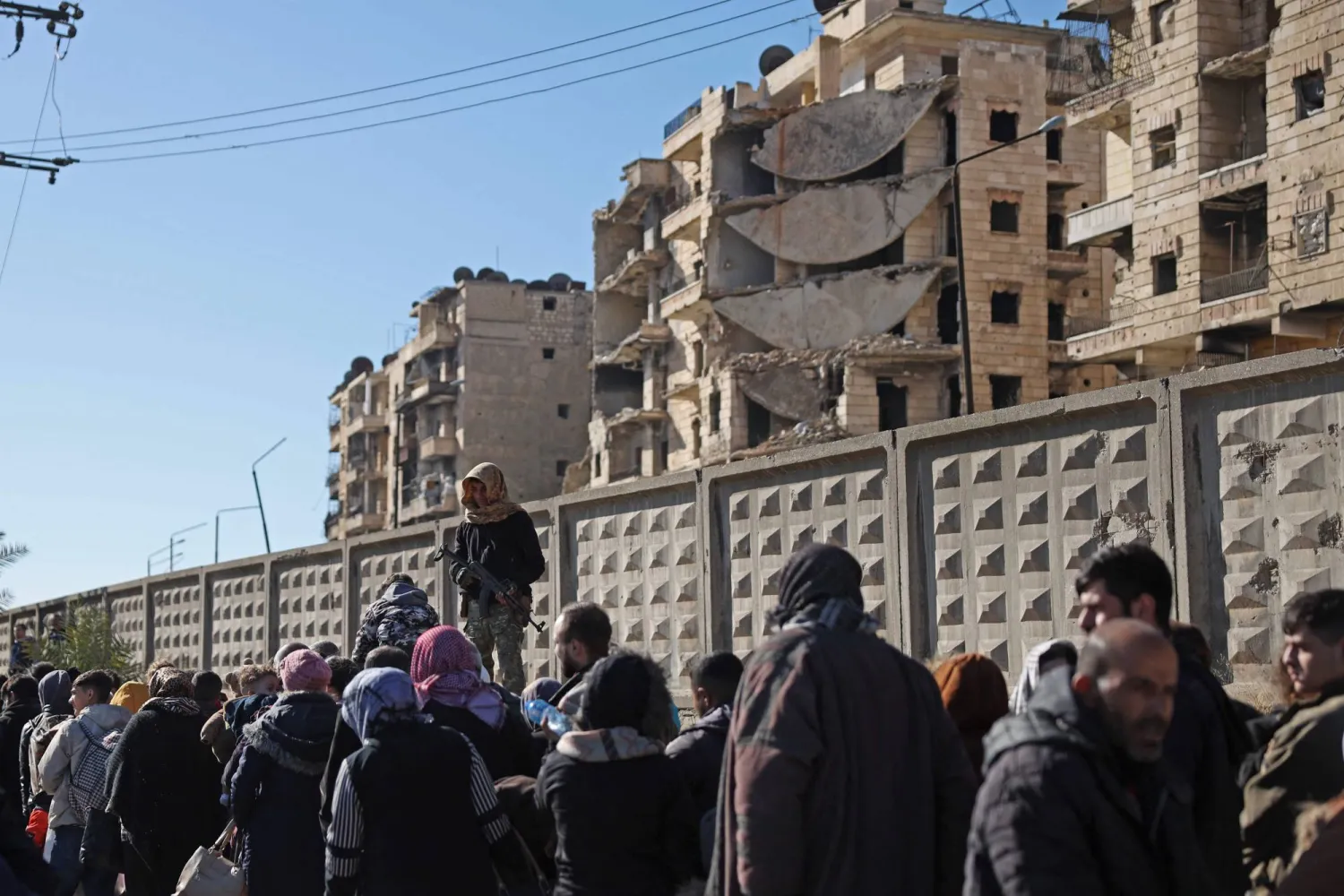 قوات الأمن التابعة للحكومة السورية تقوم بإجلاء سكان حي الشيخ مقصود في حلب (أ.ف.ب)