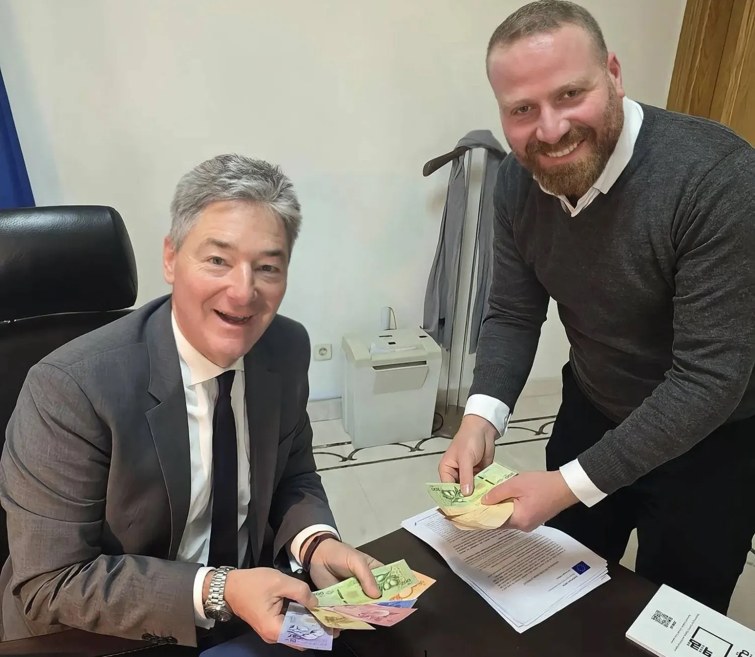 ميخائيل أونماخت القائم بأعمال بعثة الاتحاد الأوروبي في سوريا (يساراً) يمسك بأوراق العملة السورية الجديدة (حسابه عبر منصة «إكس»)