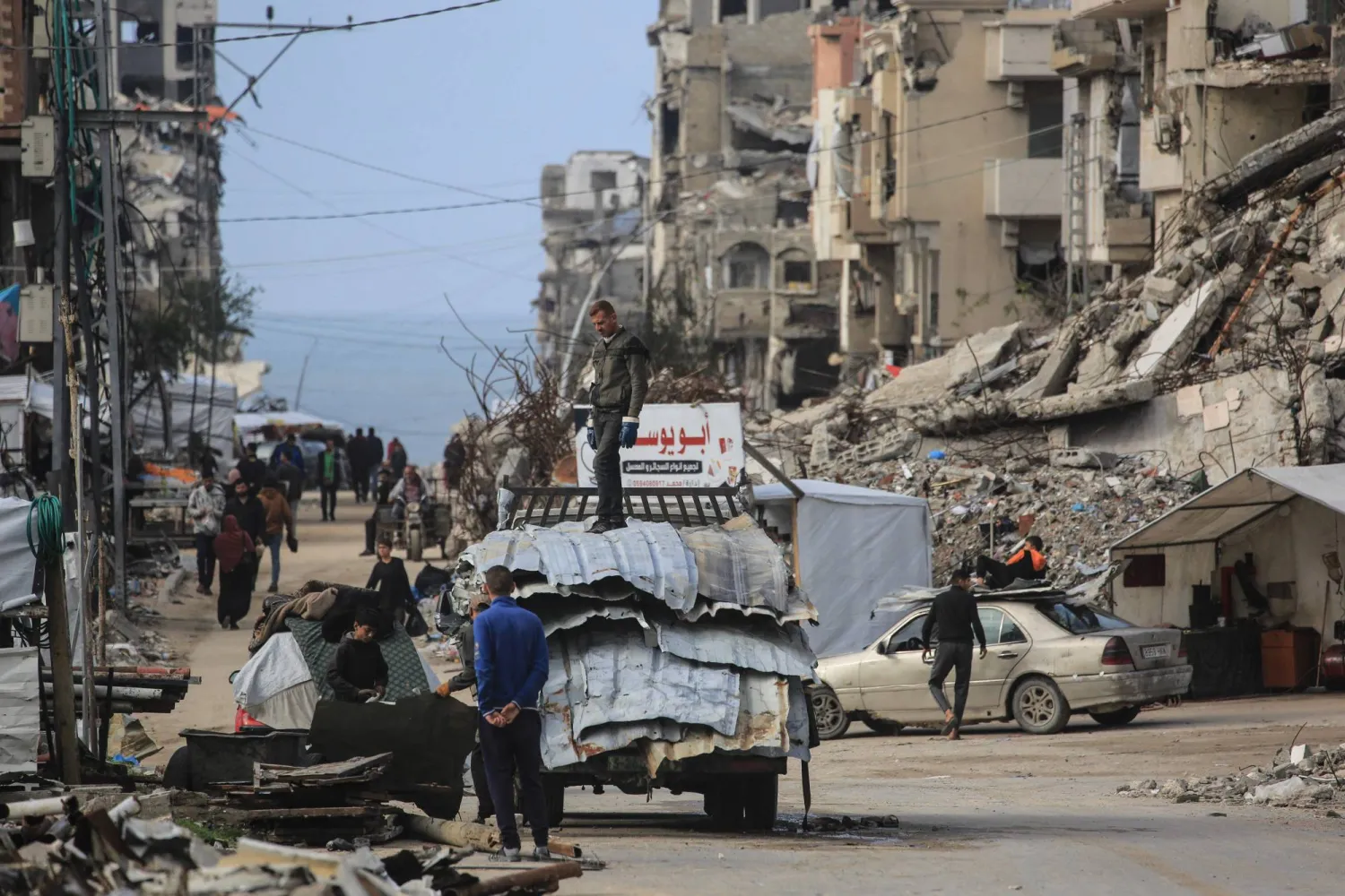 فلسطينيون يشقون طريقهم وسط المباني المتضررة جراء الحرب في جباليا بشمال قطاع غزة (أ.ف.ب)