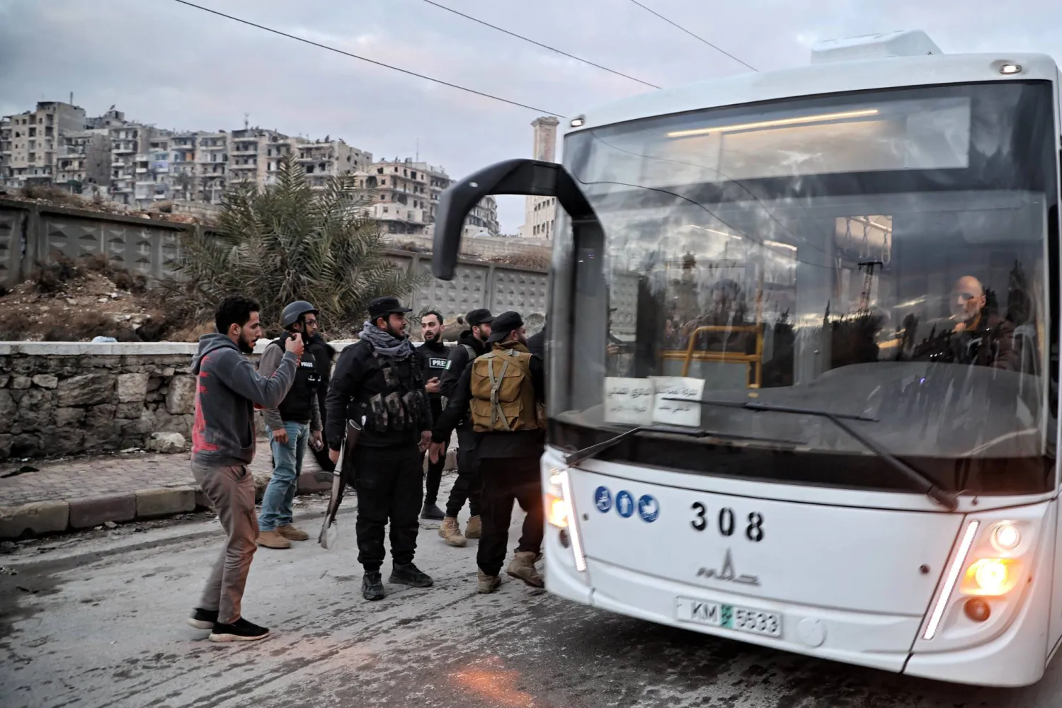 حافلة تقلّ عناصر من قوات سوريا الديمقراطية «قسد» تغادر حي الشيخ مقصود في حلب (إ.ب.أ)