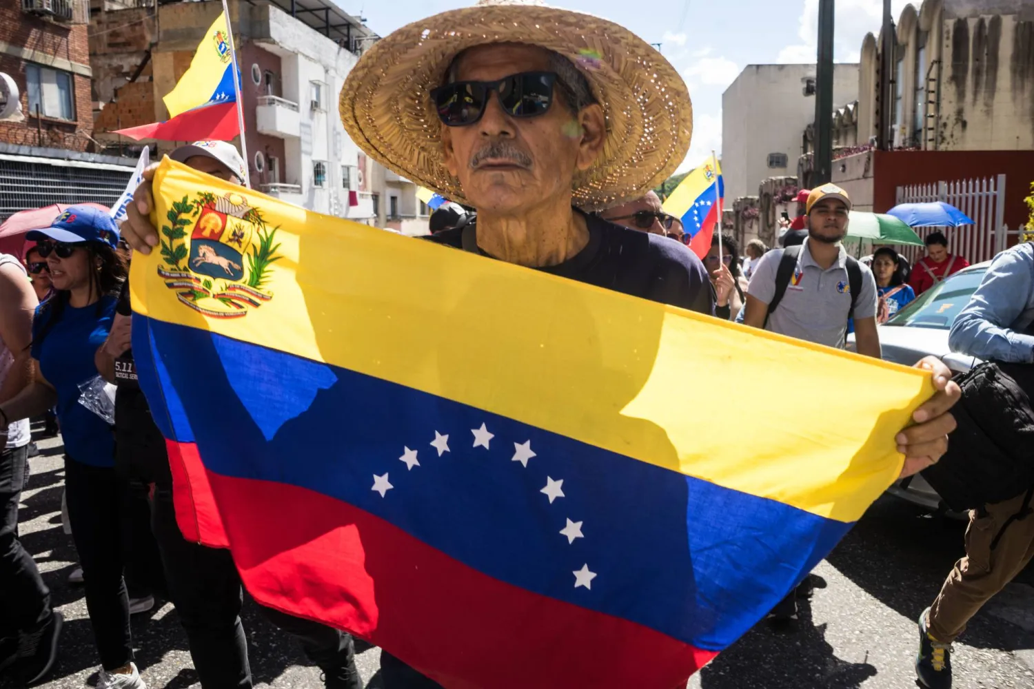 شخص يحمل العلم الفنزويلي خلال مظاهرة في كاراكاس (إ.ب.أ)