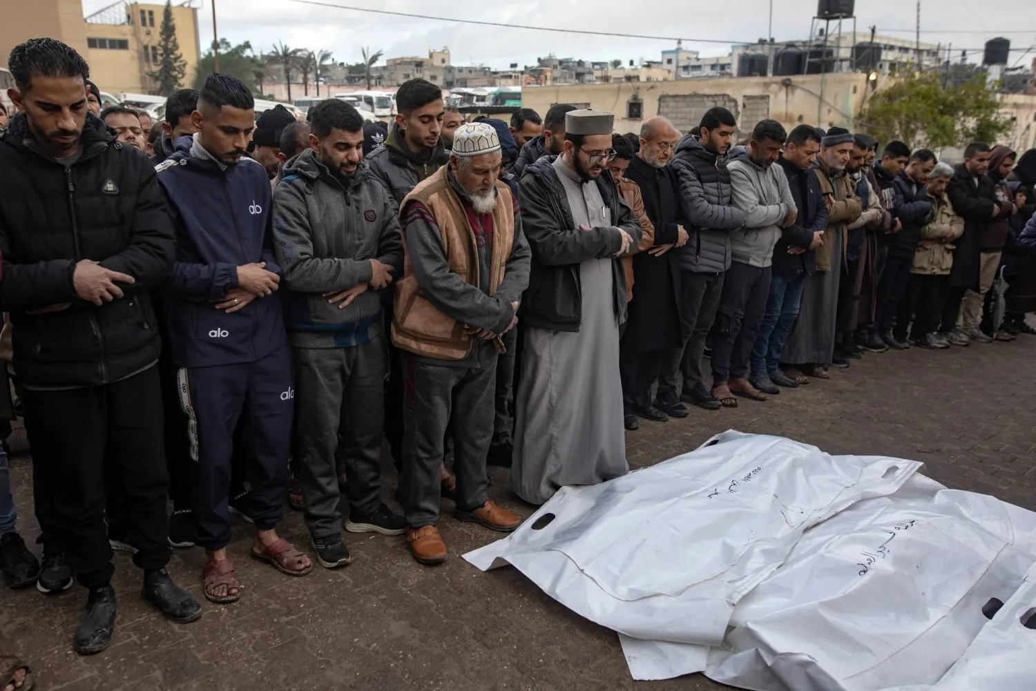 فلسطينيون يُصلُّون على جثامين ذويهم ضحايا الغارات الإسرائيلية على خان يونس بجنوب قطاع غزة (إ.ب.أ)
