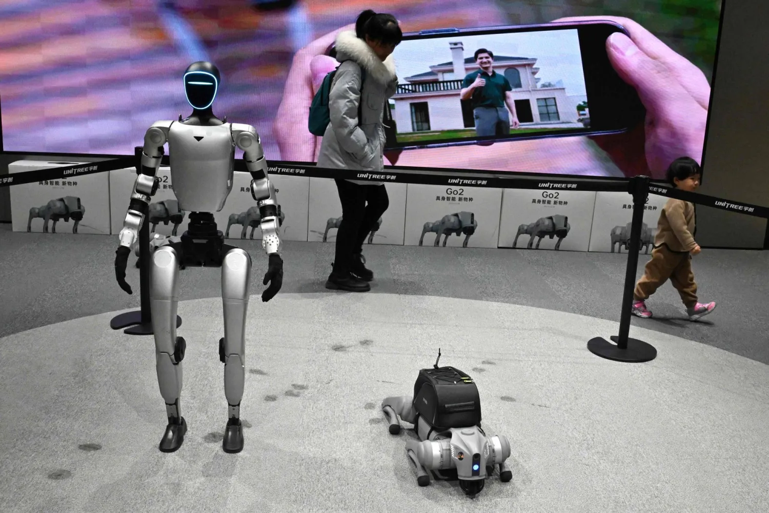 زوار يمرون بجوار الروبوتات المعروضة في أول متجر بيع بالتجزئة (أ.ف.ب)