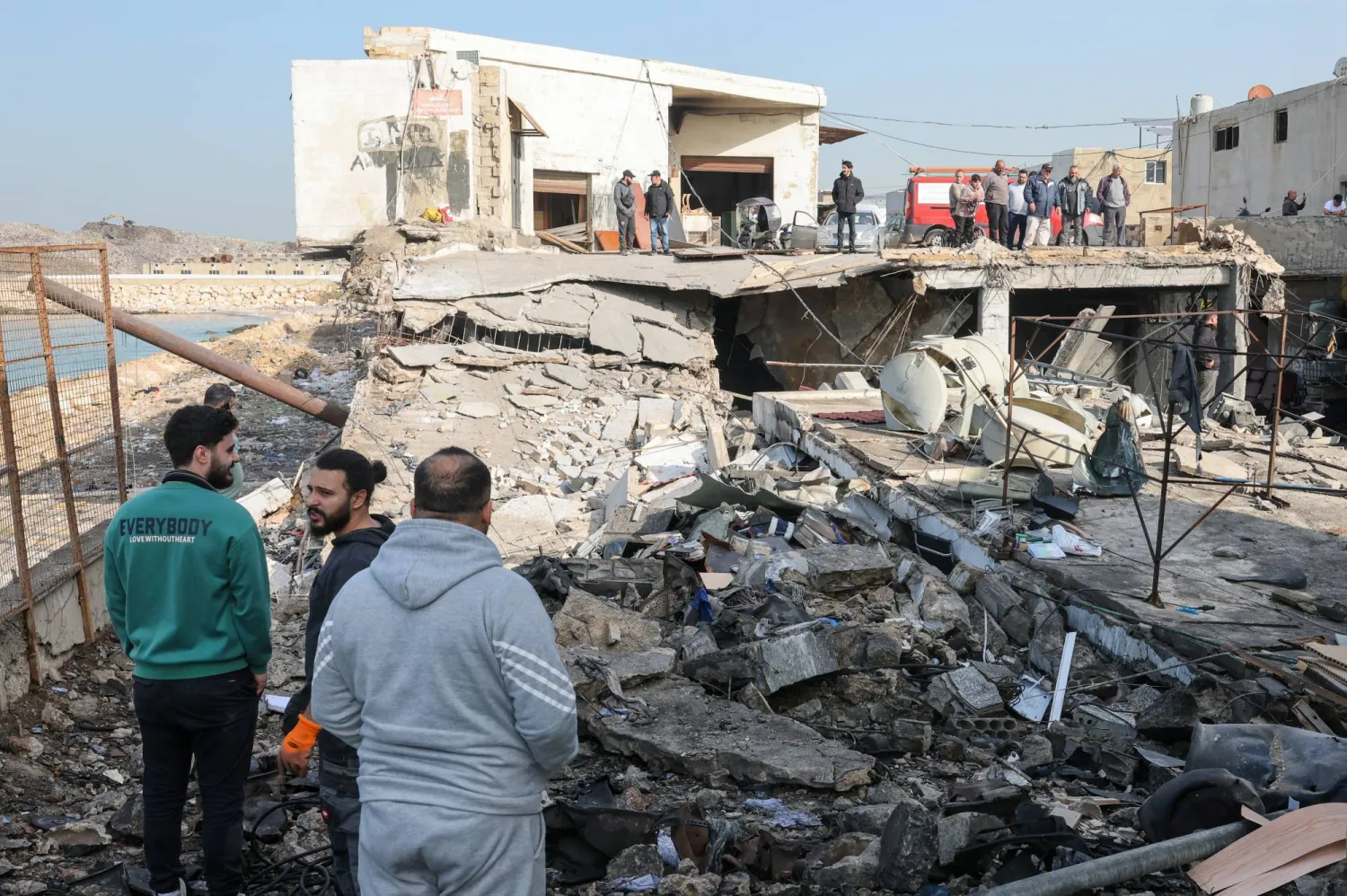 سكان يتفقدون الأضرار الناتجة عن غارات إسرائيلية استهدفت المنطقة الصناعية في صيدا عاصمة جنوب لبنان (إ.ب.أ)