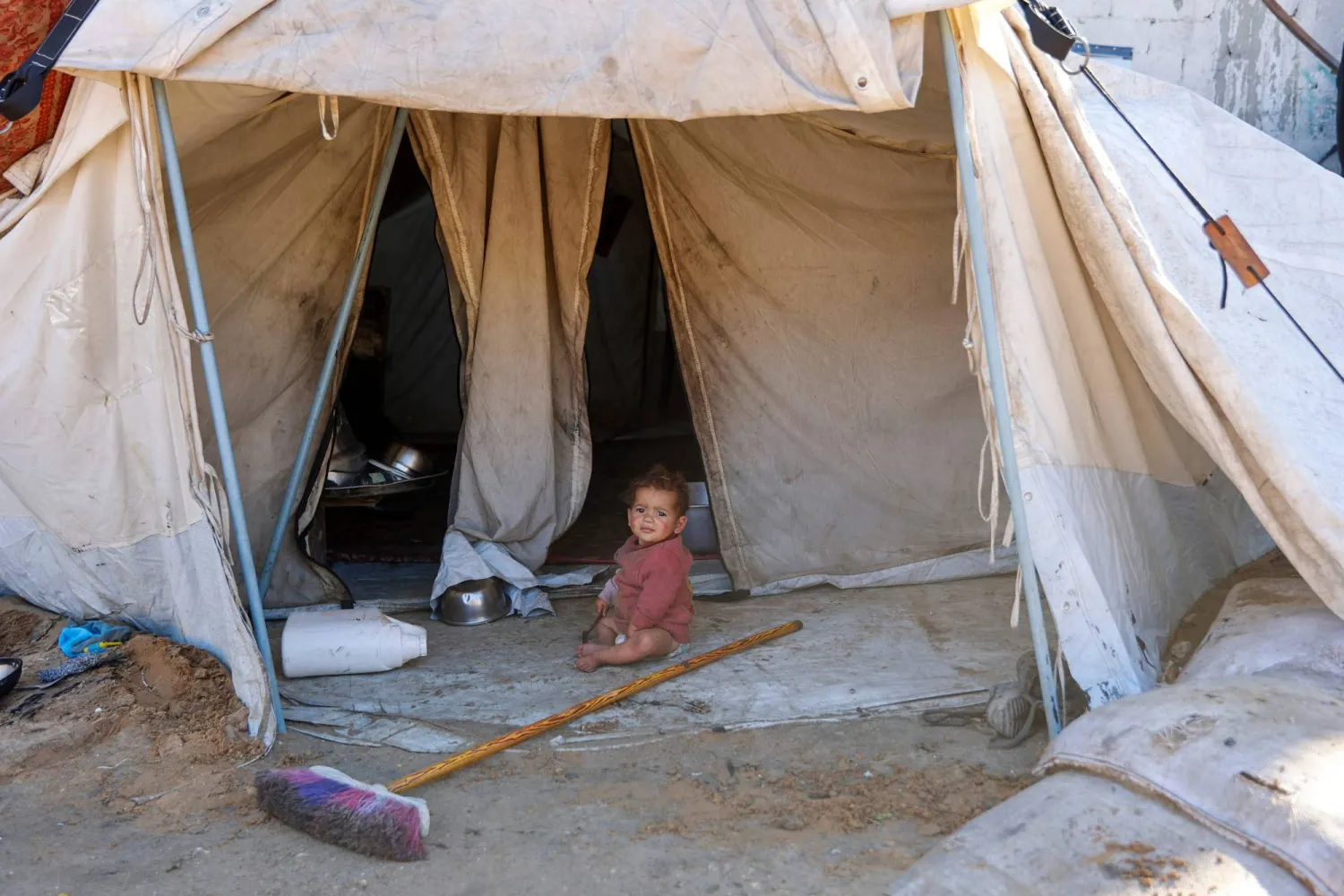 طفل فلسطيني يجلس أمام خيمة في مدينة غزة (أ.ف.ب) 