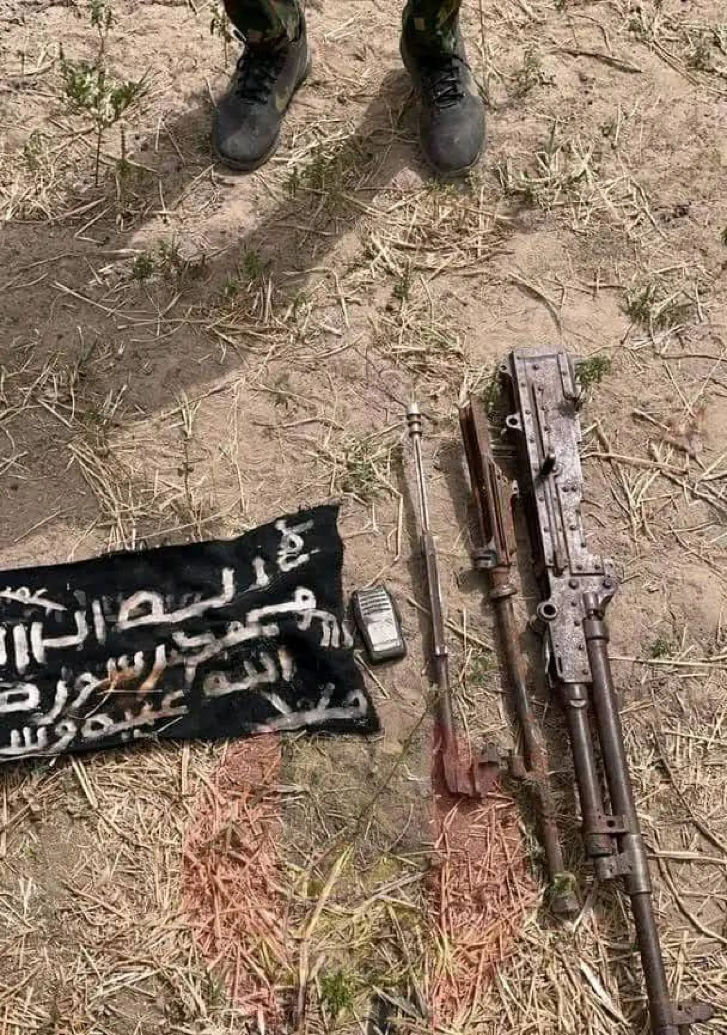 سلاح وعلم كانا بحوزة إرهابي قُتل على يد الجيش النيجيري (تواصل اجتماعي)