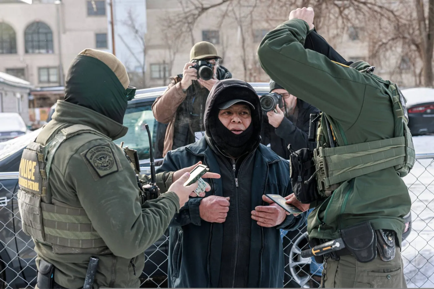 دورية من حرس الحدود الأميركي تفحص جواز سفر ووثائق أحد الأشخاص قبل اعتقاله في مينيابوليس بولاية مينيسوتا (أ.ف.ب)