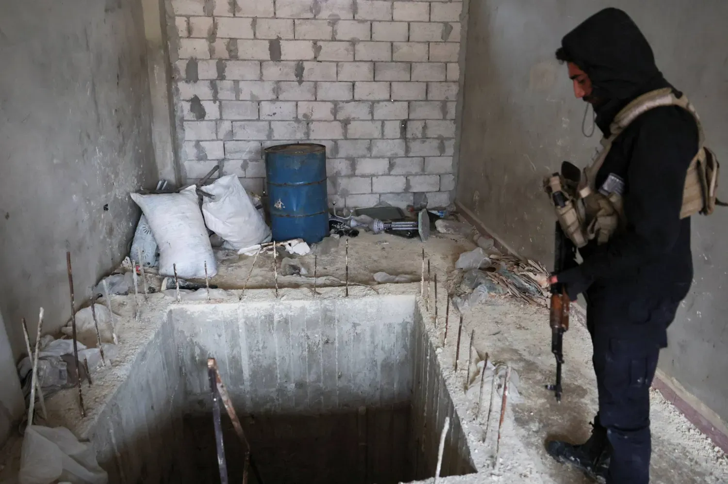 Suriye güvenlik görevlisi, pazar günü geri çekildikten sonra Suriye Demokratik Güçleri (SDG) tarafından Halep'te kullanılan bir tüneli inceliyor (Reuters)