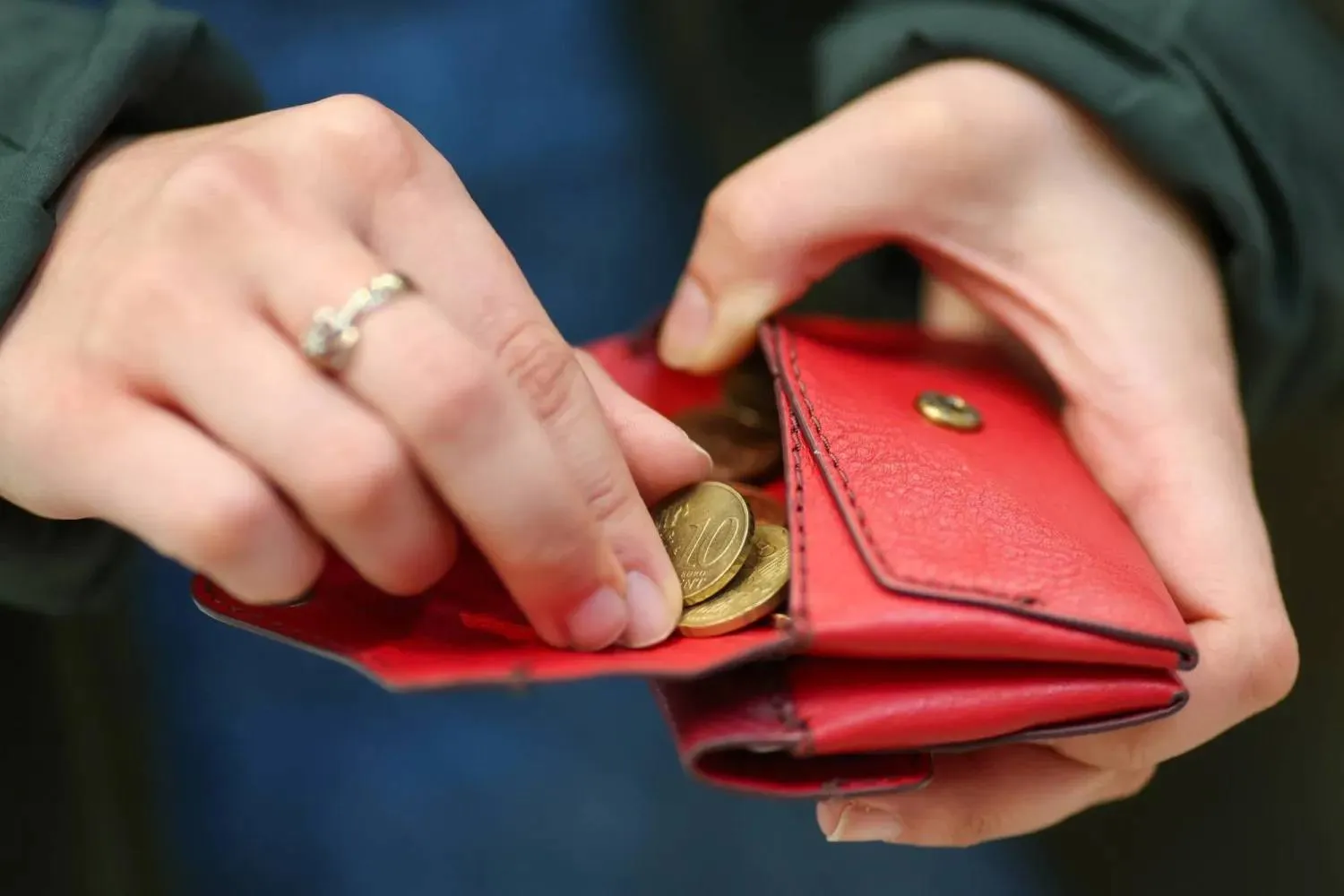 A woman places coins inside a red wallet in Germany. (dpa)