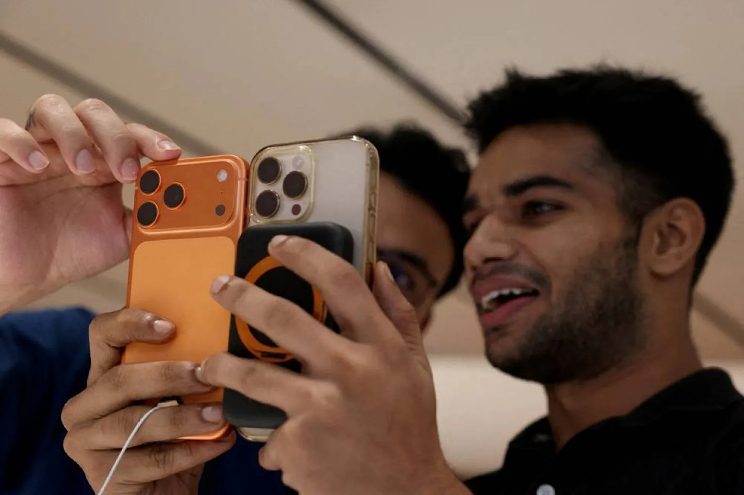 A customer compares his old iPhone with the newly launched iPhone 17 pro max at an Apple retail store in Delhi, India, September 19, 2025. (Reuters) 