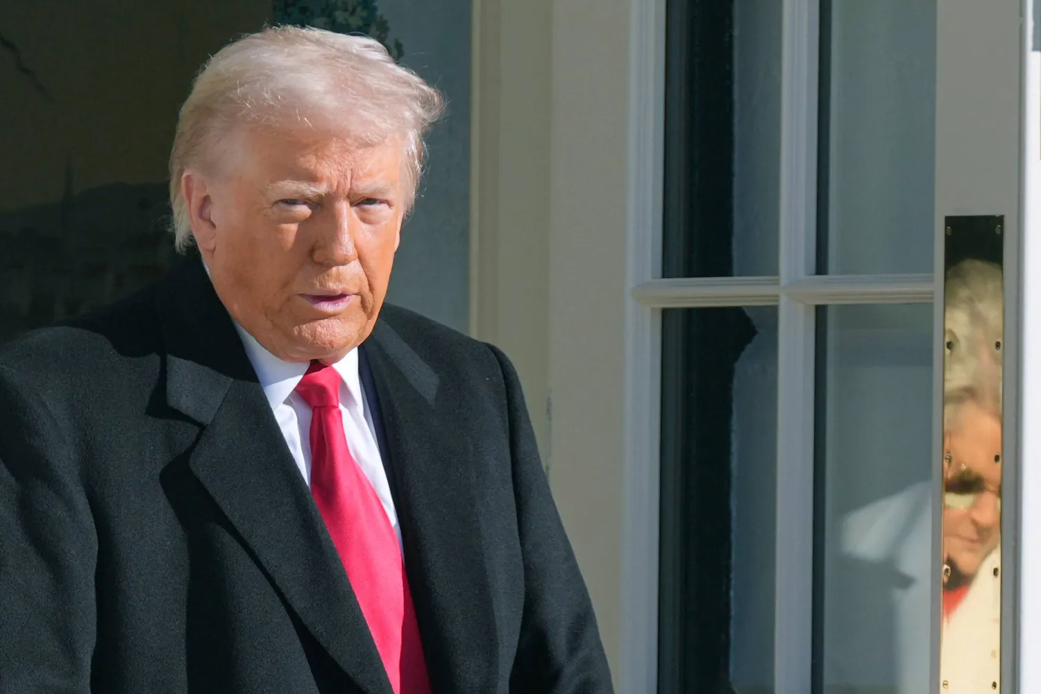  President Donald Trump and White House Chief of Staff Susie Wiles, reflected on door, leave to board Marine One, Tuesday, Jan. 13, 2026, in Washington. (AP) 