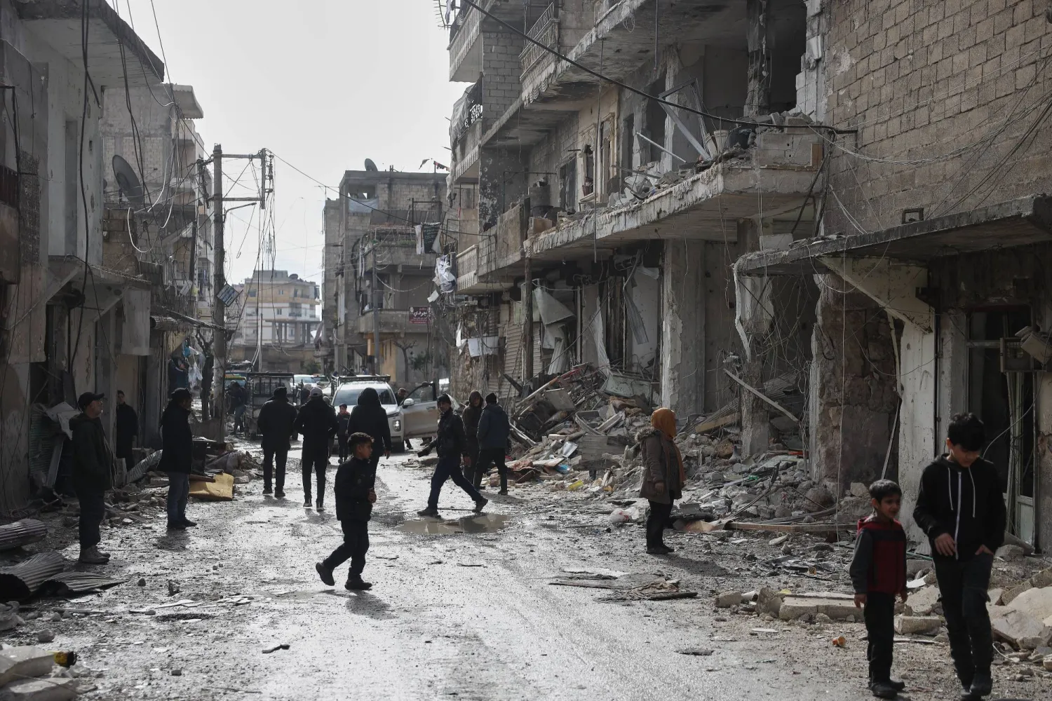 سوريون يتفقدون الأضرار التي لحقت بالأبنية في حي الشيخ مقصود بحلب بعد الاشتباكات الأخيرة (أ.ب) 