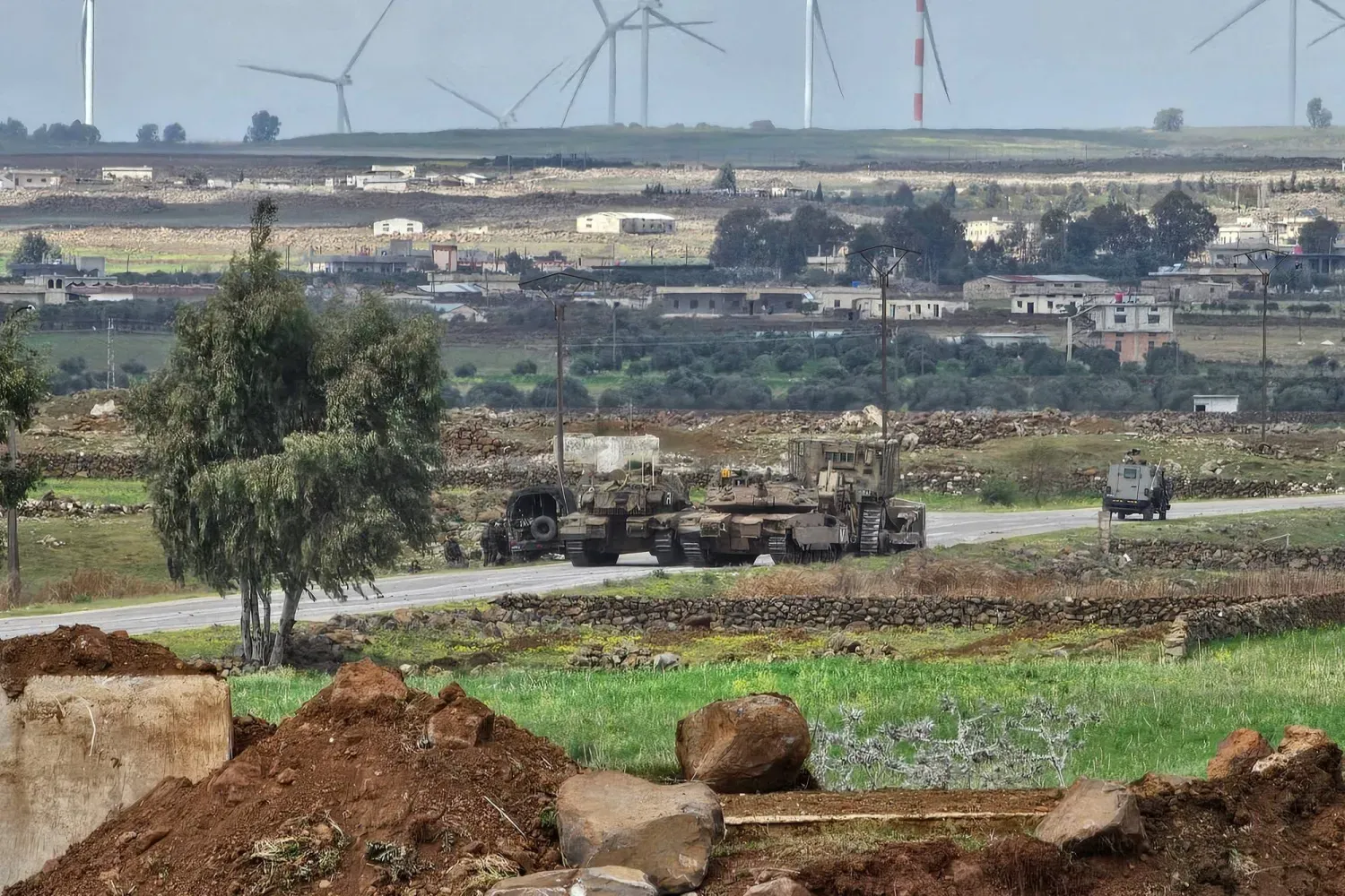 İsrail ordusuna ait tanklar ve buldozerler, 19 Mart'ta Suriye'nin Kuneytra kentinin güneyindeki Ebu Diyab Askeri Üssü’nden geçerken (AFP)