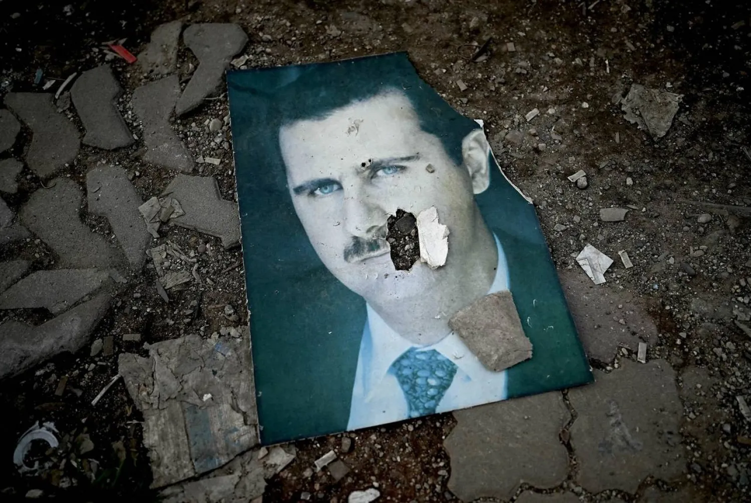 A damaged portrait of Syria's ousted President Bashar al-Assad lies on the ground in the western Syrian port city of Latakia on Dec. 15, 2024. (AFP via Getty Images) 