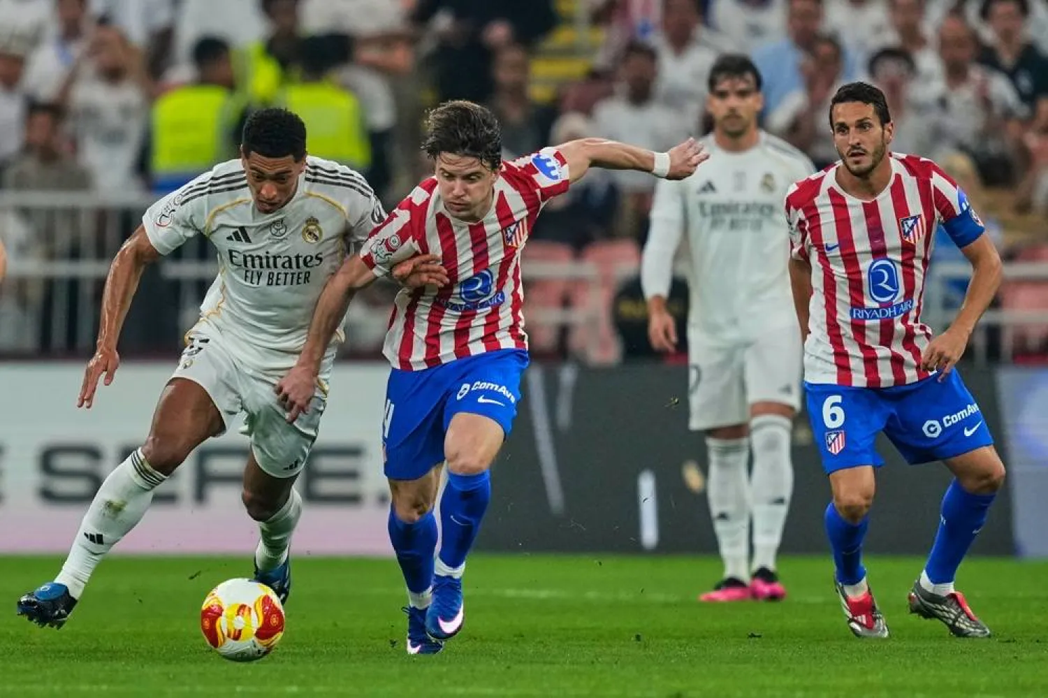 Atletico Madrid's Conor Gallagher, second left, duels for the ball with Real Madrid's Jude Bellingham during the Spanish Super Cup semifinal match at King Abdullah Sports City Stadium in Jeddah, Saudi Arabia, Thursday, Jan. 8, 2026. (AP) 