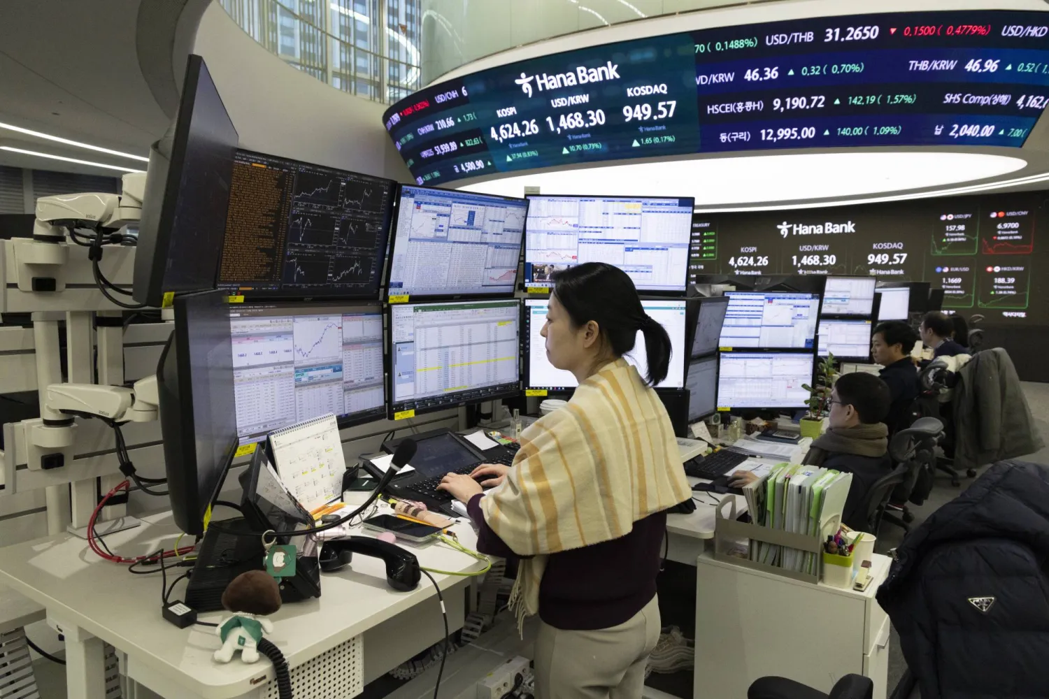 متداولون كوريون يعملون أمام شاشات تعرض مؤشرات الأسهم في بنك هانا بسيول (إ.ب.أ)
