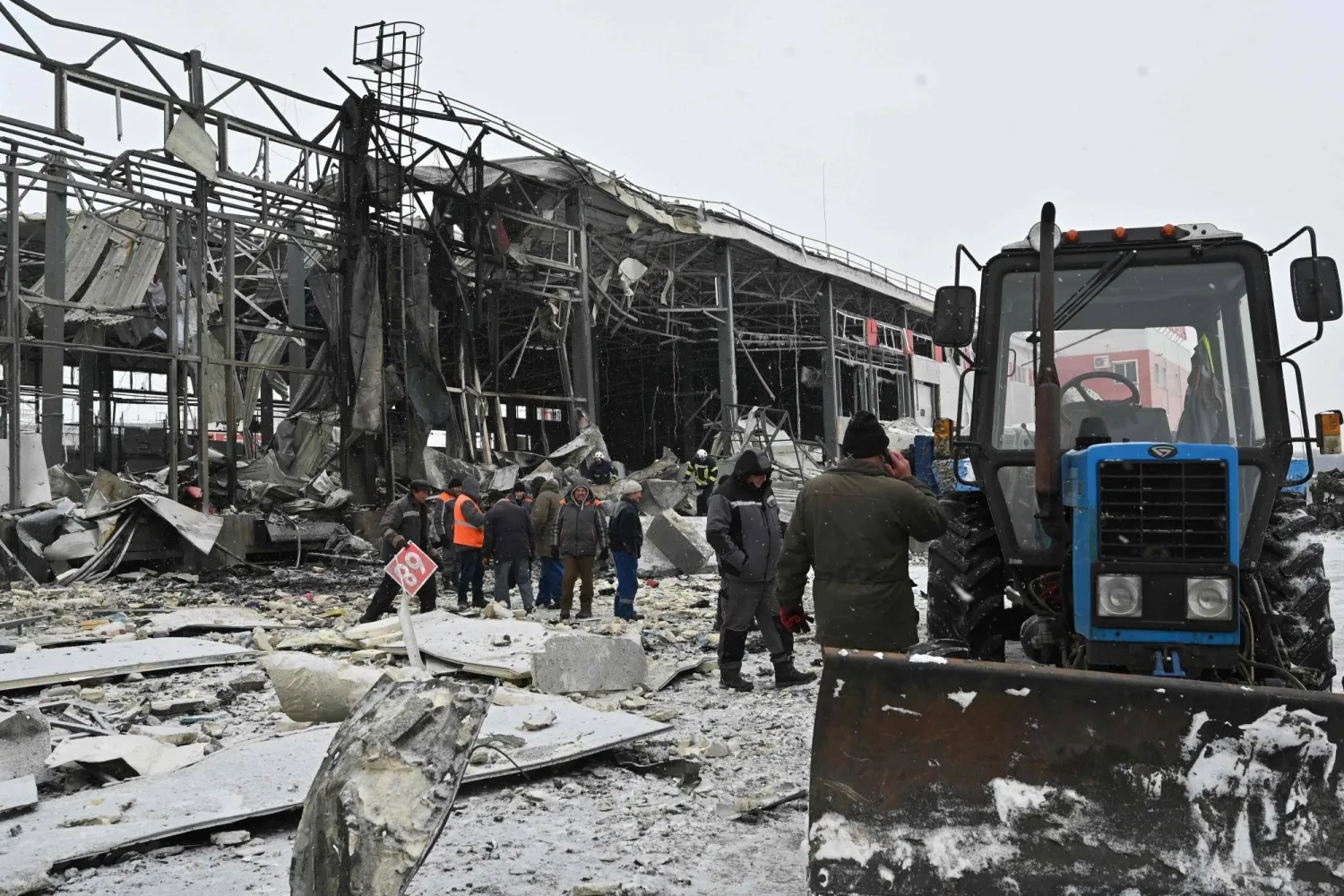  Ukrainian rescuers clear the rubble at the site of a heavily damaged Nova Poshta postal company terminal following an air attack in Novyi Korotych, Kharkiv region, on January 13, 2026, amid the Russian invasion of Ukraine. (AFP) 
