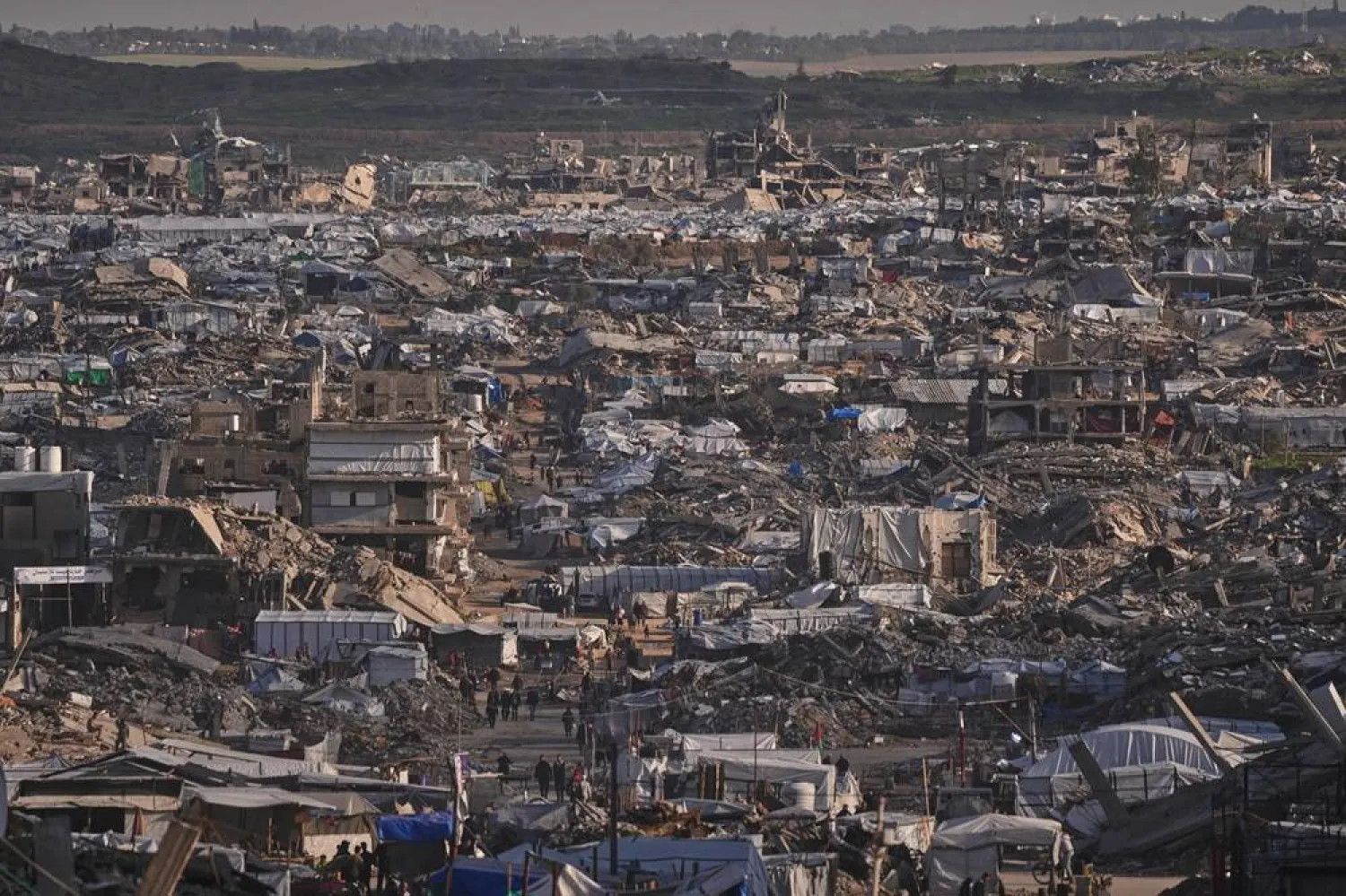  Makeshift tents shelter displaced Palestinians stand among buildings destroyed by Israeli air and ground operations in Gaza City Thursday, Jan. 15, 2026. (AP) 