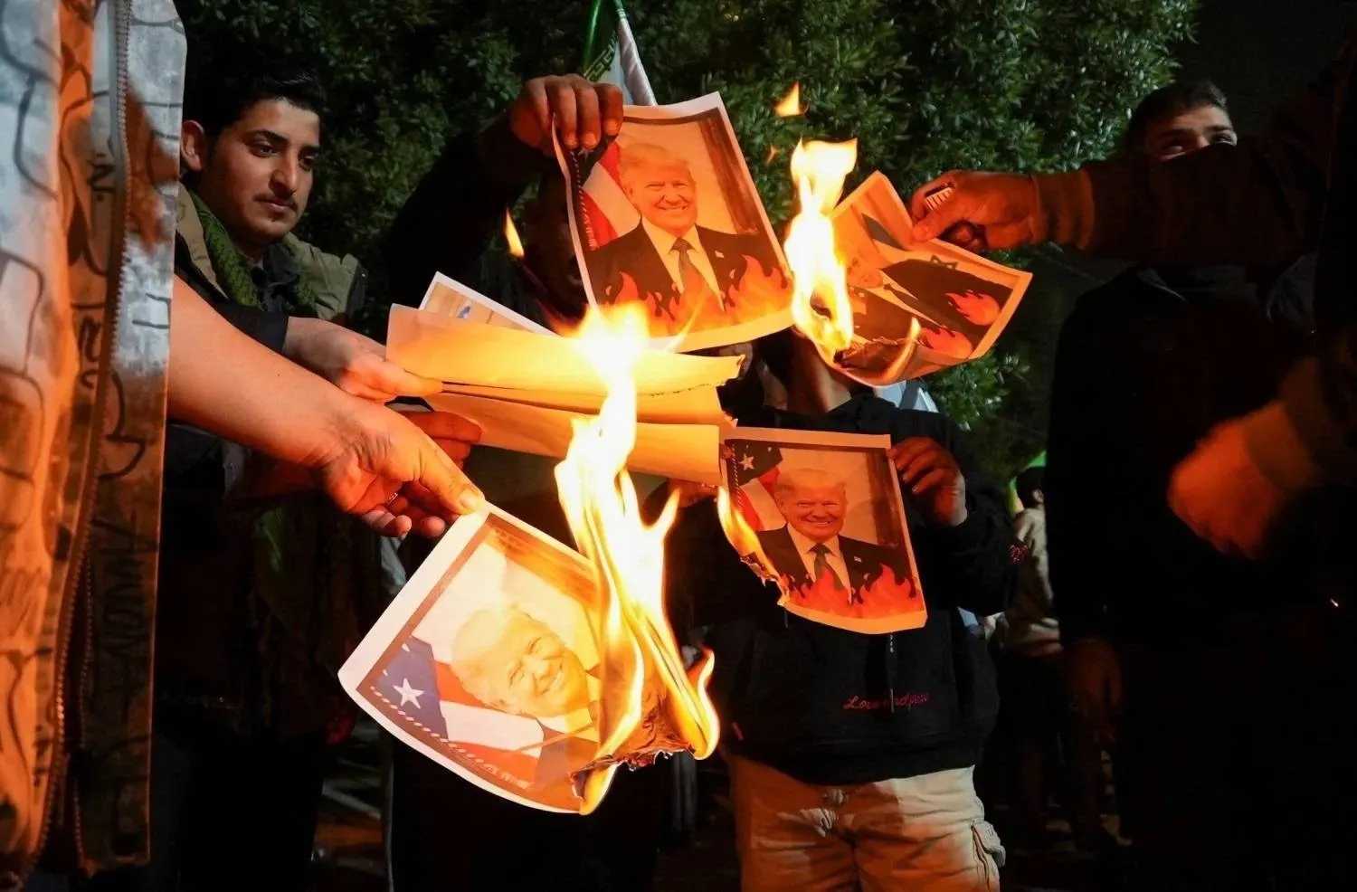 Iraqis burn pictures of US President Donald Trump and Israeli Prime Minister Benjamin Netanyahu outside the Iranian consulate in Basra, January 13, 2026 (Reuters). 