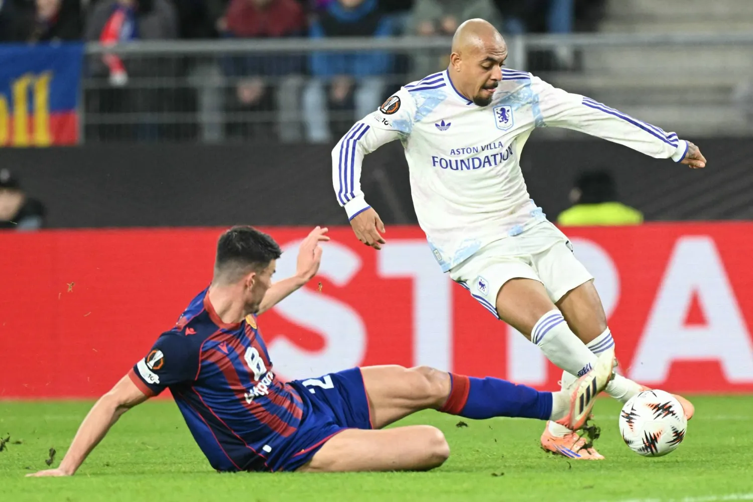 (FILES) Aston Villa's Dutch forward #17 Donyell Malen (R) fights for the ball with Basel's Austrian defender #24 Flavius Daniliuc (L) during the UEFA Europa League, league phase, football match between FC Basel and Aston Villa at the St Jakob-Park stadium, in Basel on December 11, 2025. (Photo by SEBASTIEN BOZON / AFP)