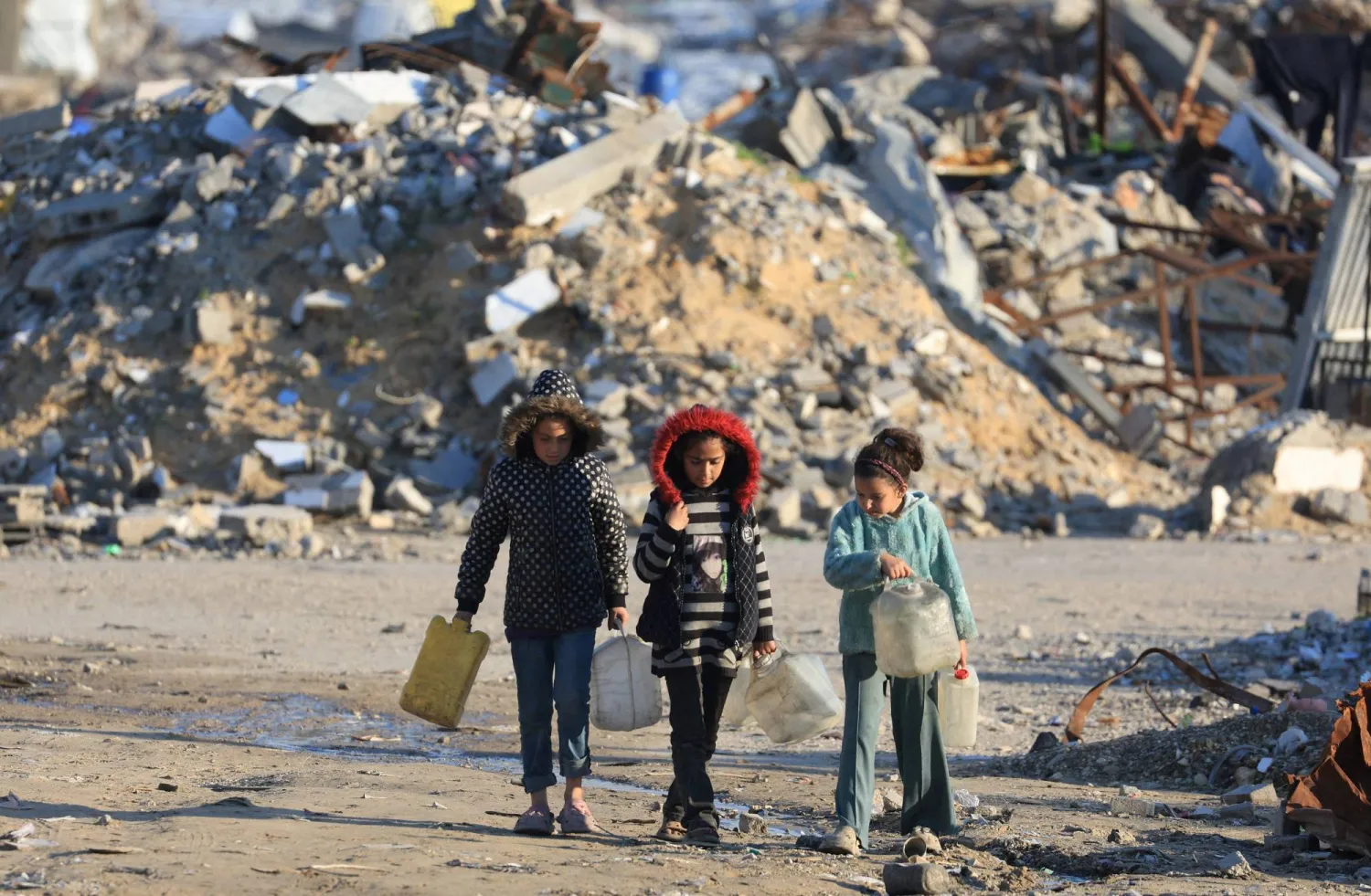 FILE PHOTO: Palestinian girls walk past the rubble of residential buildings destroyed during the war, in Gaza City, January 16, 2026. REUTERS/Dawoud Abu Alkas/File Photo