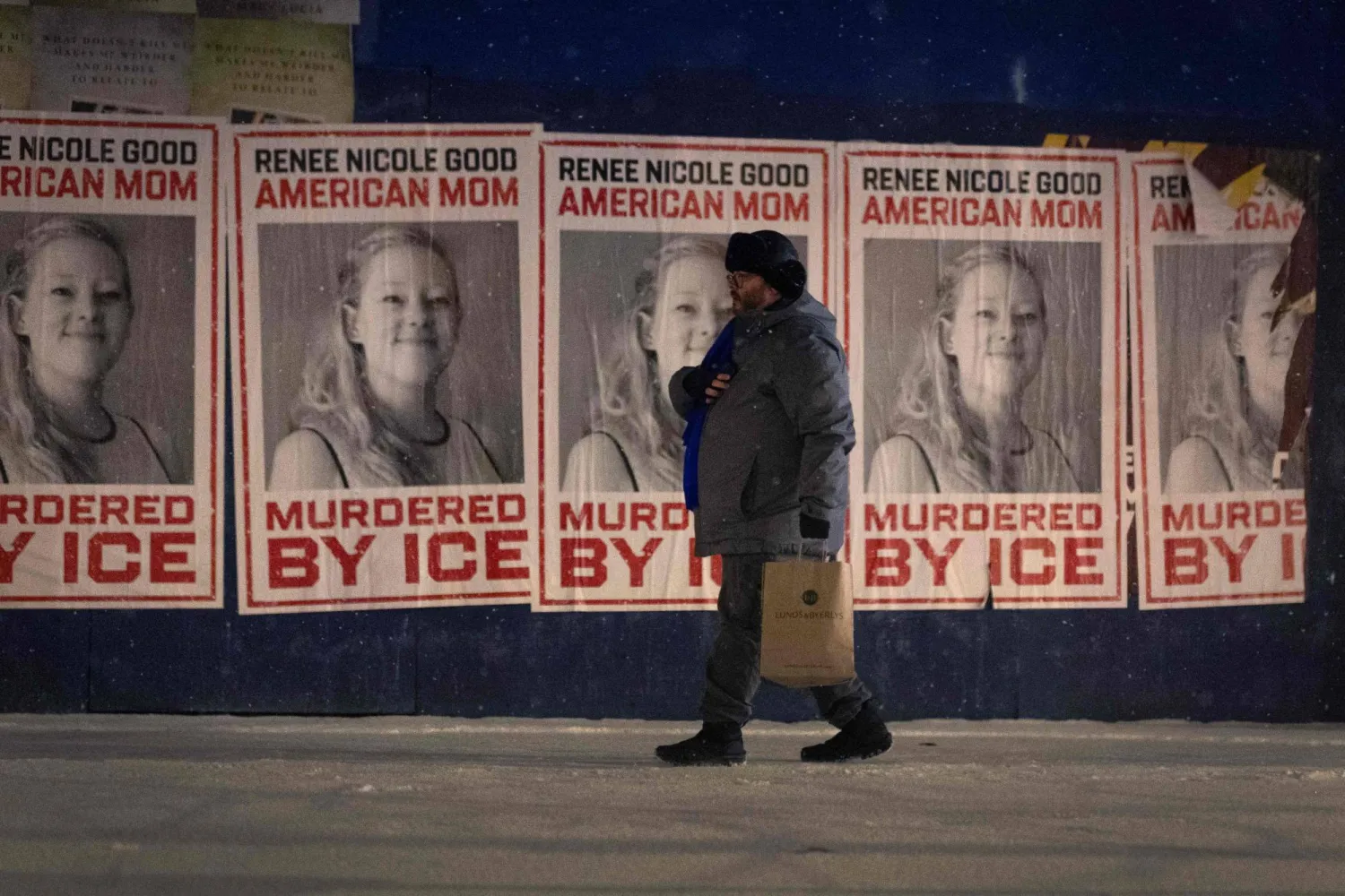 رجل يمر بجوار مجموعة من الملصقات التذكارية لرينيه غود في 16 يناير 2026 بمينيابوليس (أ.ف.ب)