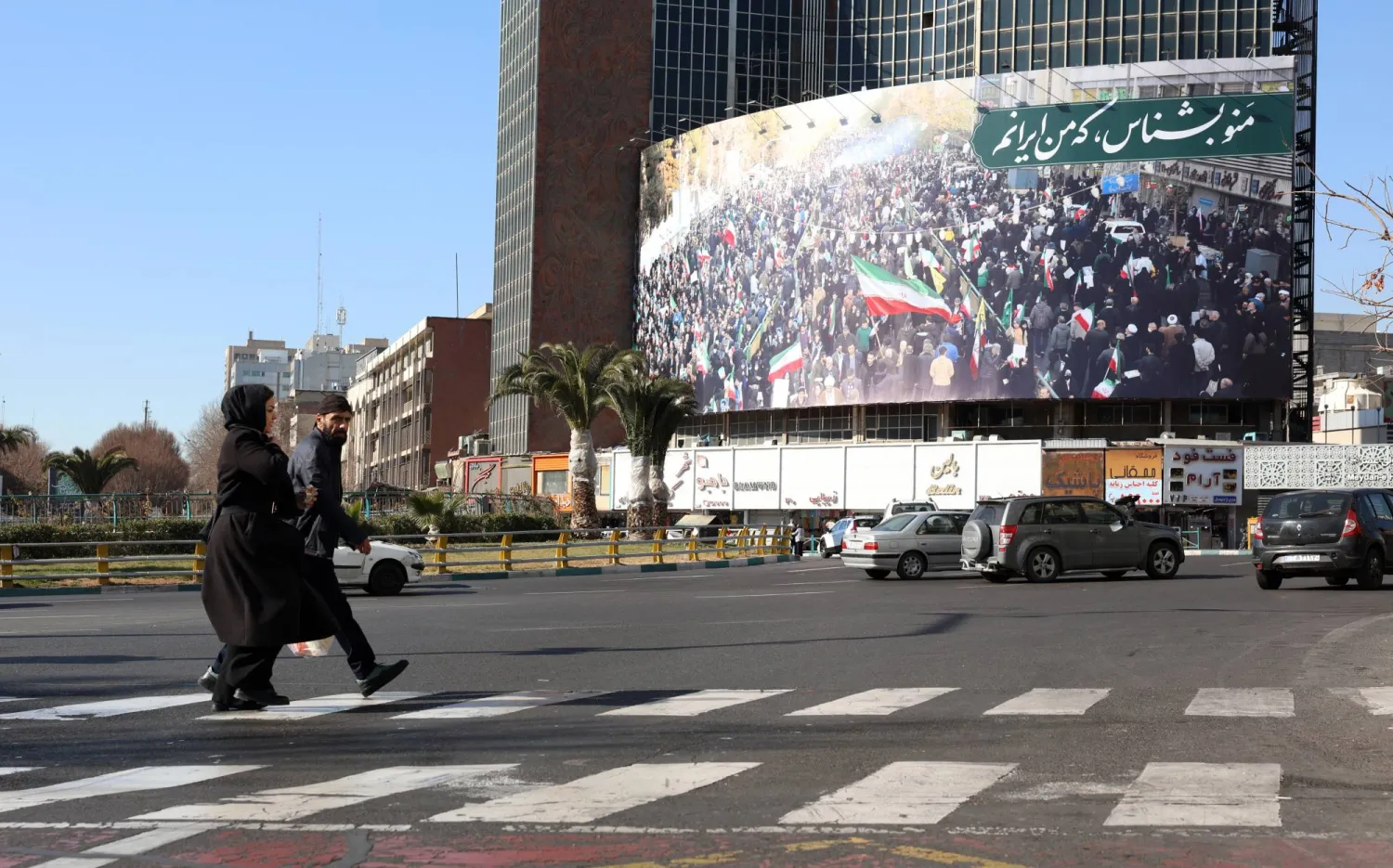 إيرانيون يسيرون في أحد شوارع طهران (إ.ب.أ)
