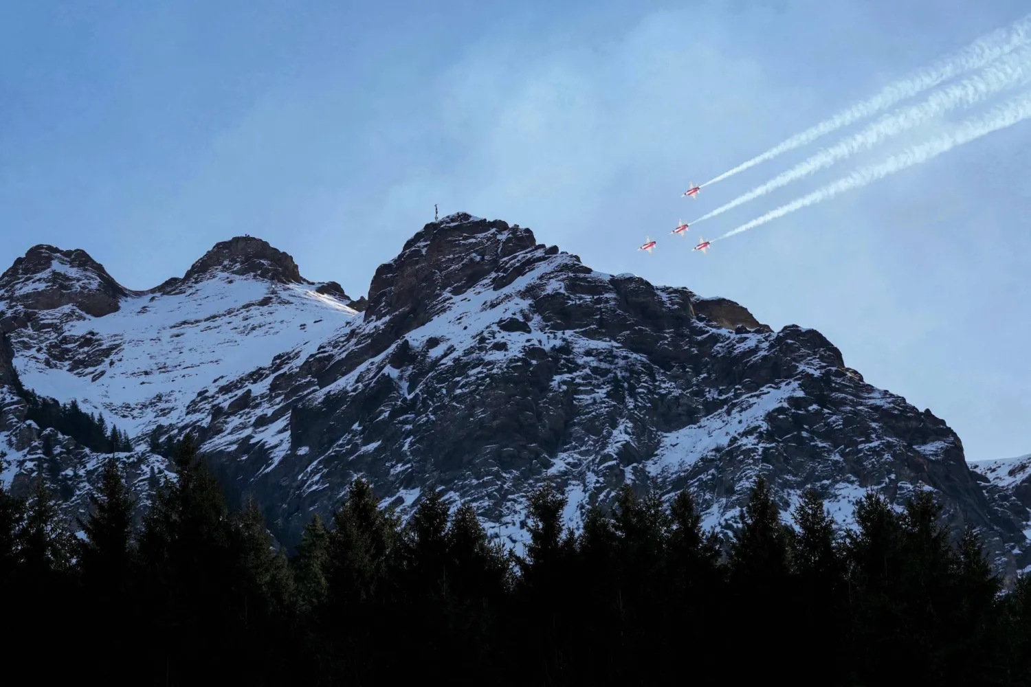 Swiss Air Force's aerobatic team "The Patrouille Suisse" perform prior to the FIS alpine skiing Men's World Cup Super G event in Wengen, Swiss Alps, on January 19, 2026. (Photo by Dimitar DILKOFF / AFP)