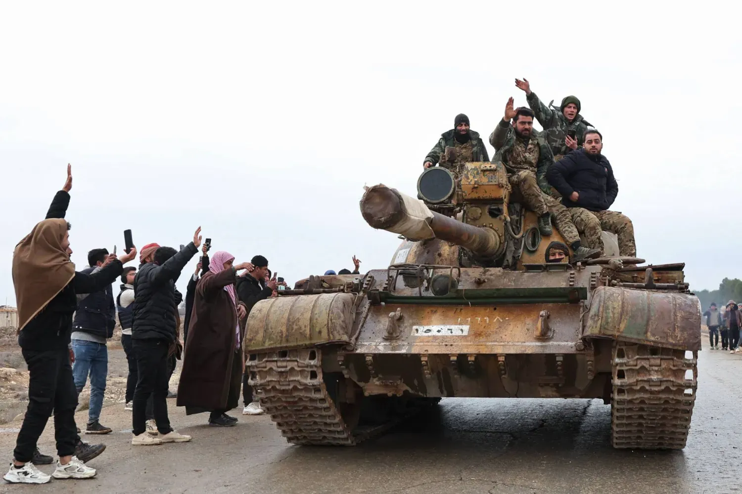 Suriye askerleri, dün SDG güçlerinin çekilmesinin ardından Halep'in doğusundaki kırsal kesimde bulunan Meskene kentine bir tankın üzerinde girdiler (AFP