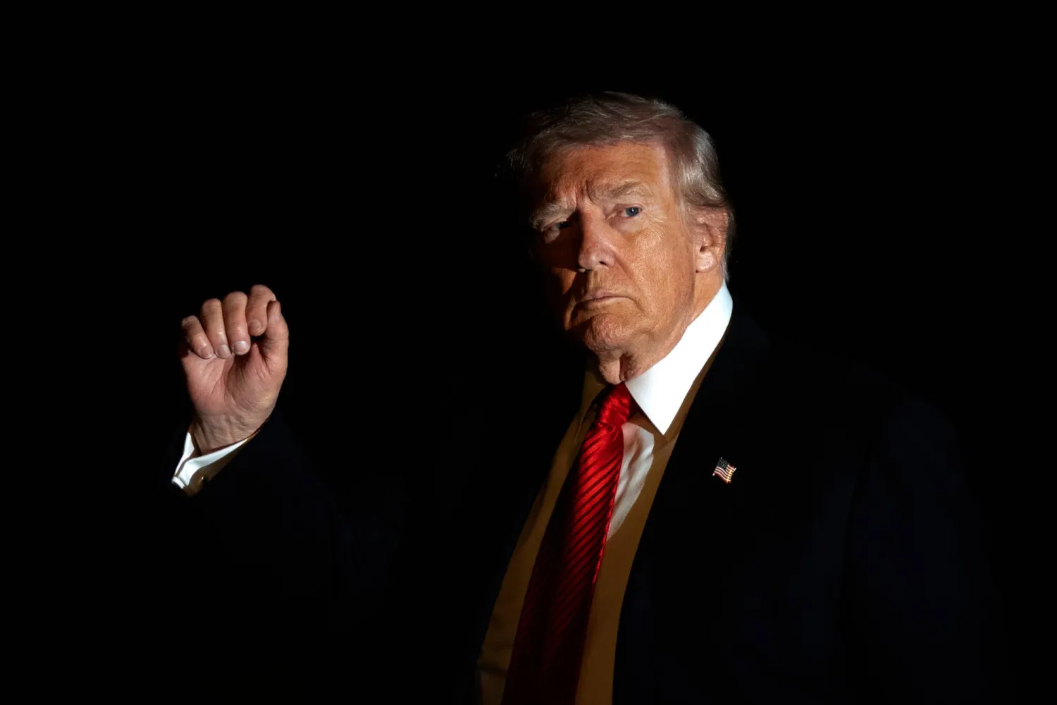 FILE - President Donald Trump is illuminated by a camera flash as he gestures while walking across the South Lawn of the White House, Nov. 2, 2025, in Washington, after returning from a trip to Florida. (AP Photo/Mark Schiefelbein, File)