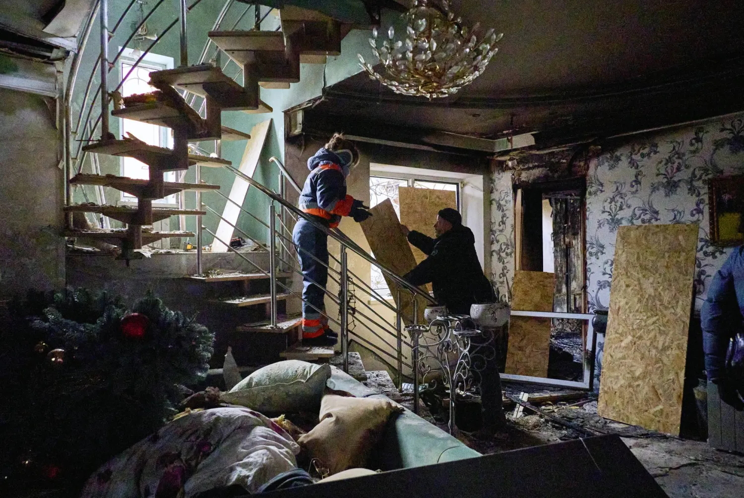 شخصان داخل مبنى سكني استهدفته غارة روسية في خاركيف شمال شرقي أوكرانيا الأحد (إ.ب.أ)