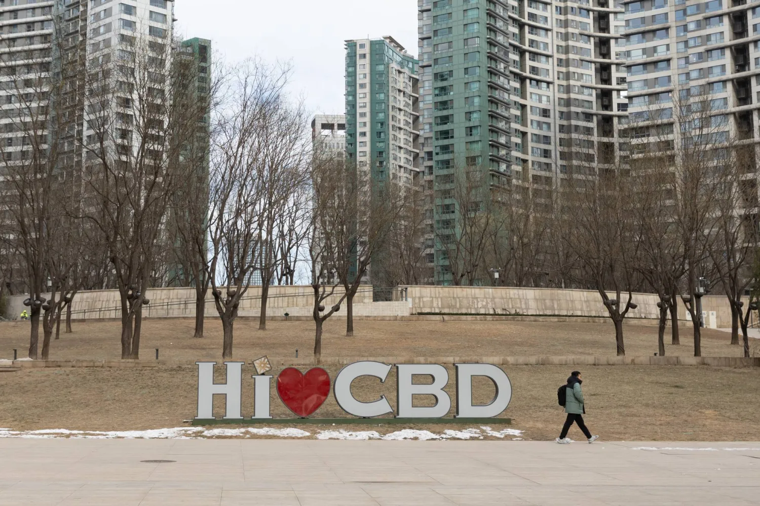 شخص يمر بجوار لافتة في الحي التجاري المركزي ببكين (إ.ب.أ)