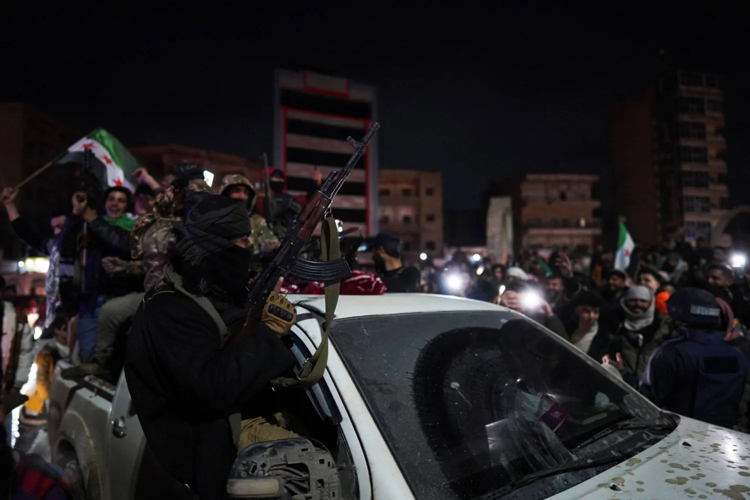 أفراد من الجيش السوري يحتفلون بدخول مدينة الرقة عقب انسحاب «قوات سوريا الديمقراطية» (رويترز)