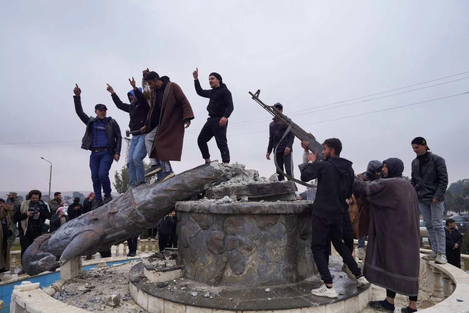 A group of civilians smash a statue of a Syrian Democratic Forces fighter in the city of Tabqa after the Syrian army took control of it, in Tabqa, Syria, January 18, 2026. REUTERS/Karam al-Masri TPX IMAGES OF THE DAY
