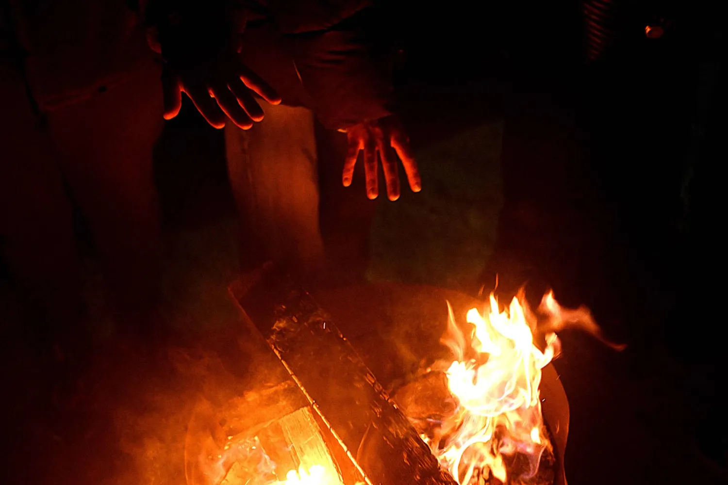Local residents gather around a bonfire during an outdoor party to keep warm as many apartments remain without heating in Kyiv on January 18, 2026, amid the Russian invasion of Ukraine. (AFP)