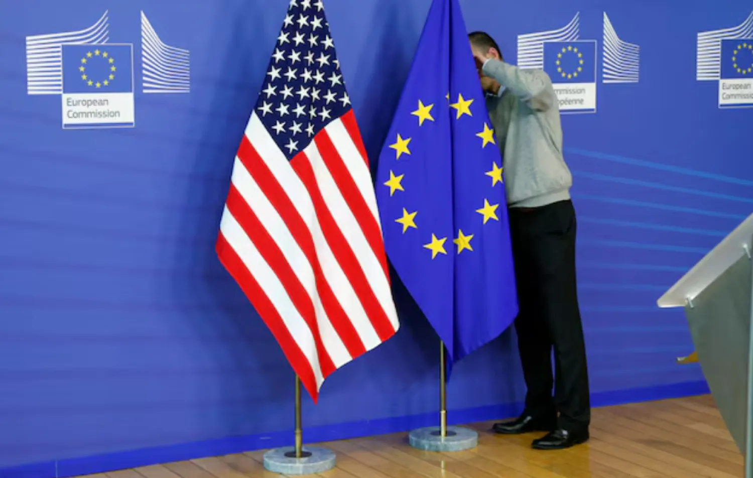 A worker adjusts European Union and US flags at the EU Commission headquarters in Brussels, November 11, 2013. 