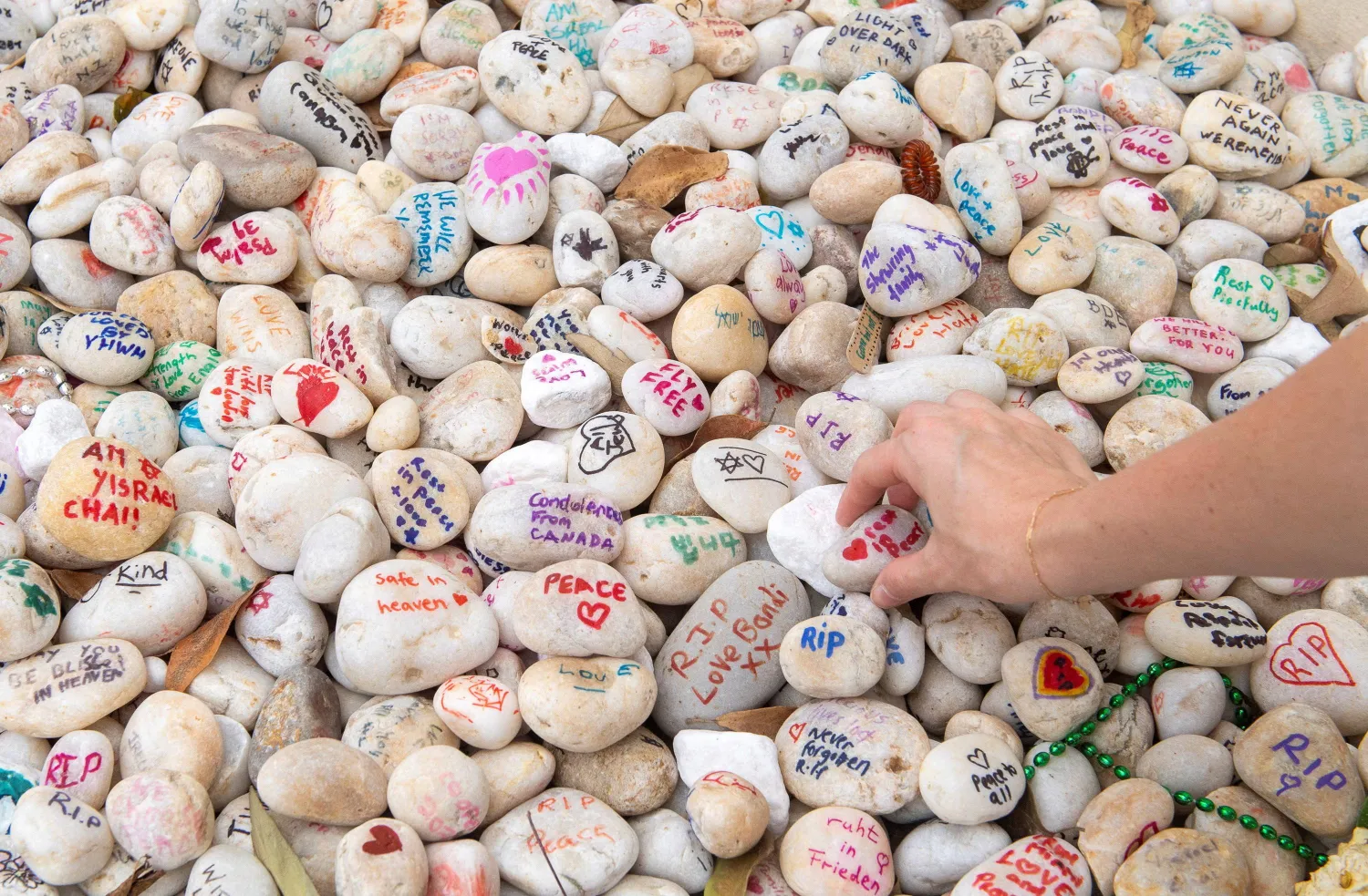 A visitor places a pebble at a memorial site in remembrance to the lives lost during the Bondi Beach mass shooting on December 14, 2025, in Sydney, Australia, January 16, 2026. (Reuters)