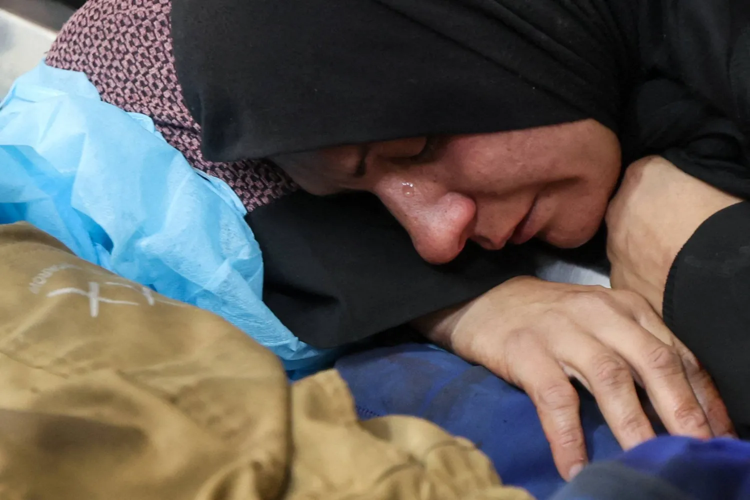 فلسطينية تبكي أمام جثمان أحد قتلى الغارات الإسرائيلية على قطاع غزة (رويترز)