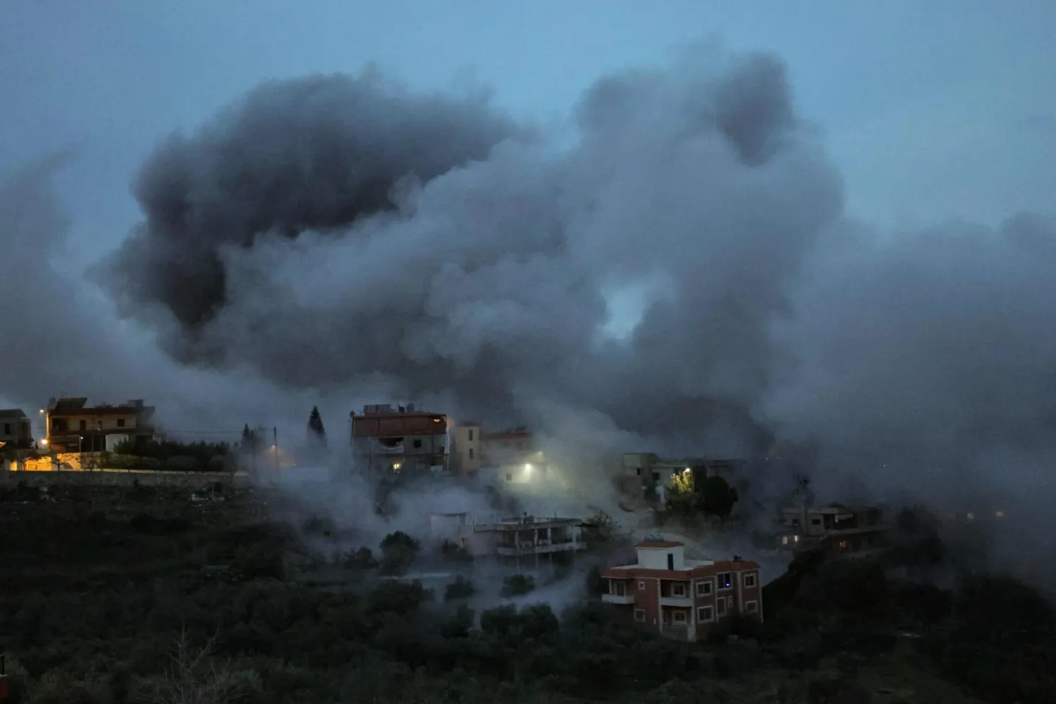 Smoke and sparks ascend from the site of an Israeli airstrike that targeted a building in the southern Lebanese village of Kfour on January 21, 2026. (AFP)