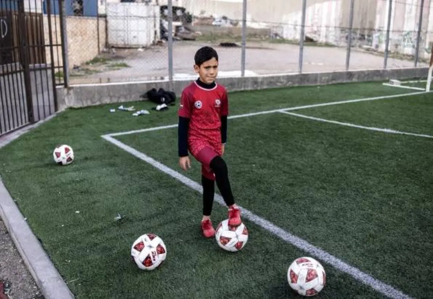 Aida Mülteci Kampı’ndaki bir futbol sahasında top oynayan Filistinli bir çocuk (AFP)