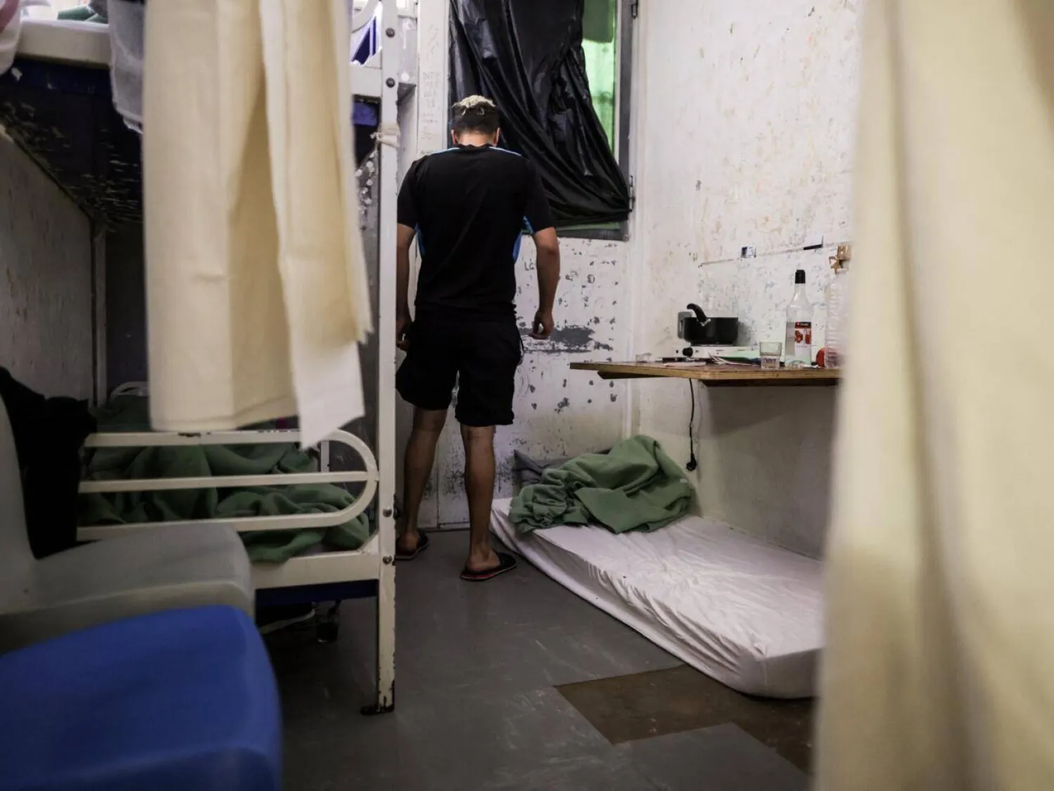 An inmate stands in his two-person cell near a mattress set for a third inmate at Gradignan prison, near Bordeaux, southwestern France, on October 3, 2022. Thibaud Moritz, AFP
