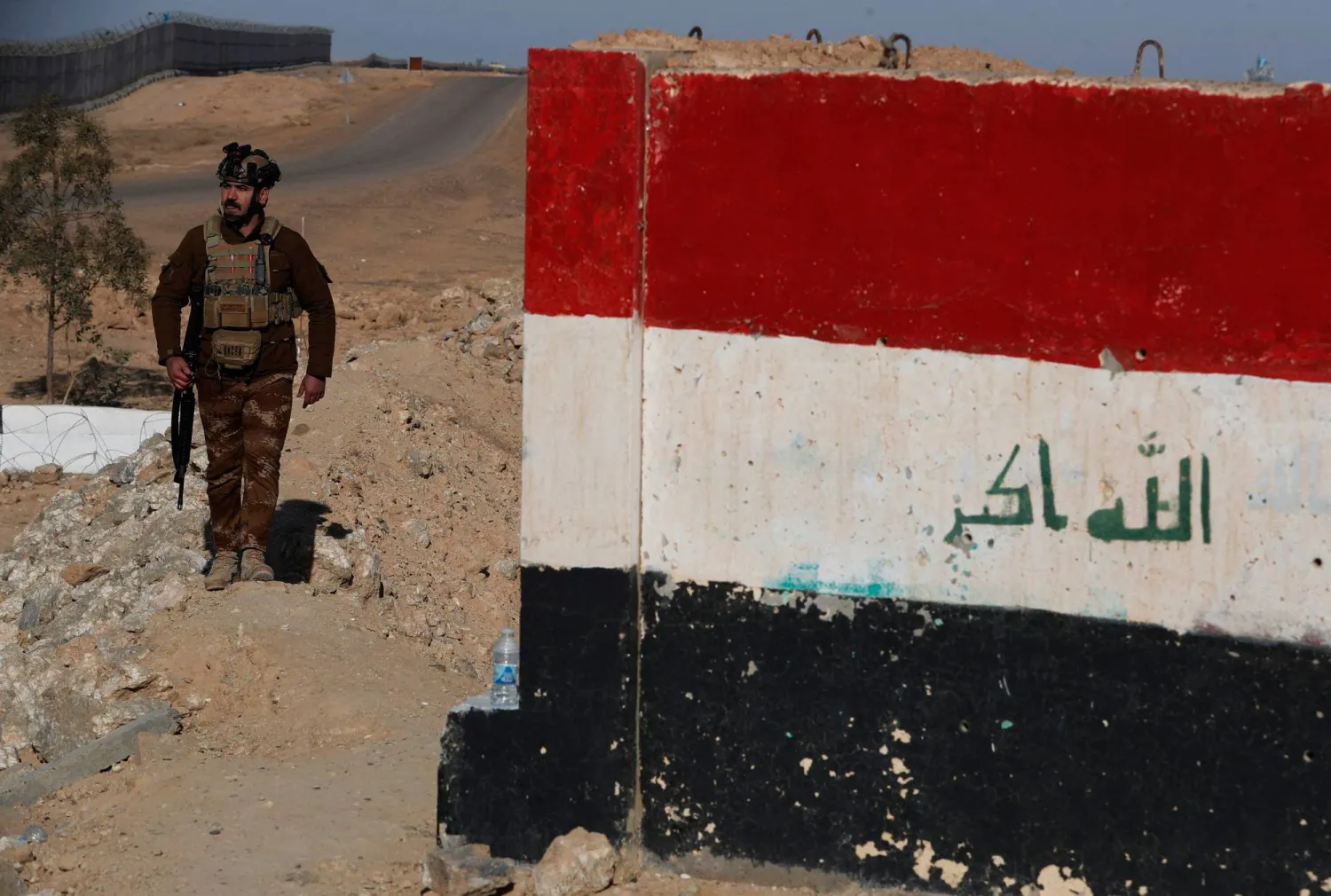 أحد أفراد قوات حرس الحدود العراقية يقوم بدورية على طول جدار خرساني على الحدود العراقية السورية 21 يناير 2026 (أ.ف.ب)