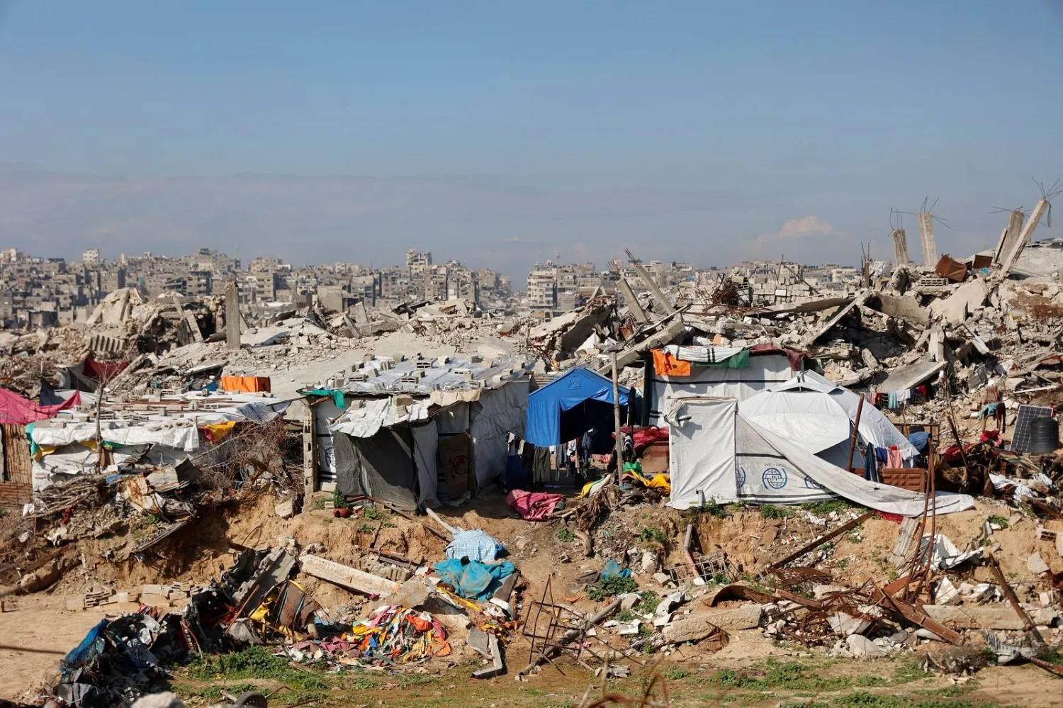 فلسطينيون نازحون يعيشون وسط الأنقاض والحطام الذي خلّفه الجيش الإسرائيلي في مخيم جباليا للاجئين شمال قطاع غزة (أ.ف.ب)