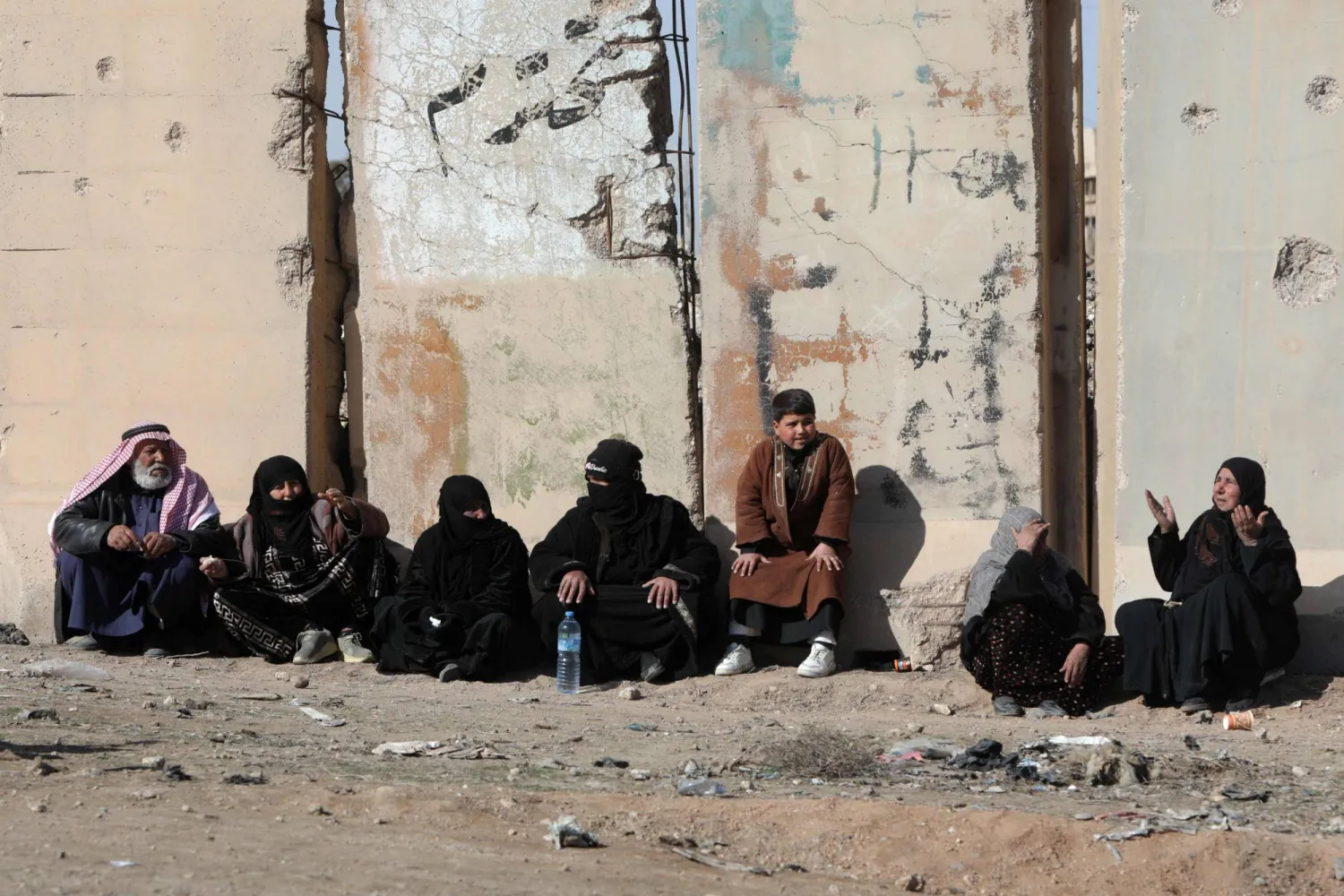 انتظار عائلات المحتجزين في سجن الأقطان الواقع على مشارف مدينة الرقة شمال شرقي سوريا خارج السجن في محاولة للحصول على أخبار عن ذويهم الأربعاء (أ.ف.ب)