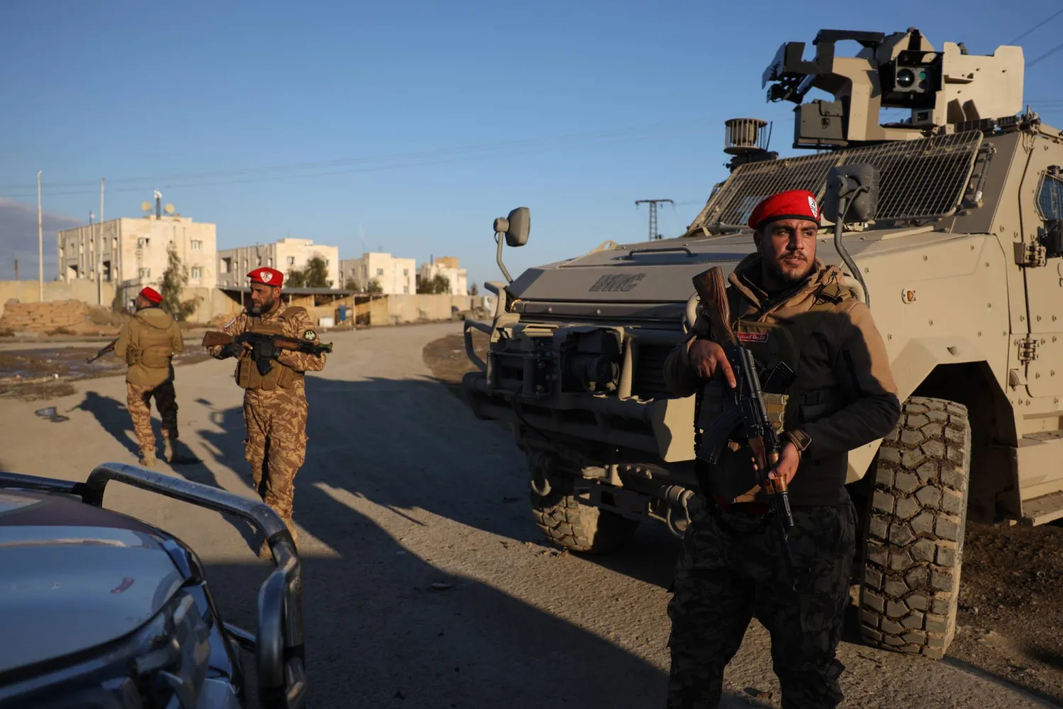 Syrian government forces stand guard outside Al-Aqtan prison on the outskirts of Raqqa, northeastern Syria, Monday, Jan. 19, 2026, as negotiations are underway between the Syrian government and the Kurdish-led Syrian Democratic Forces over a withdrawal from the prison. (AP Photo/Omar Albam)