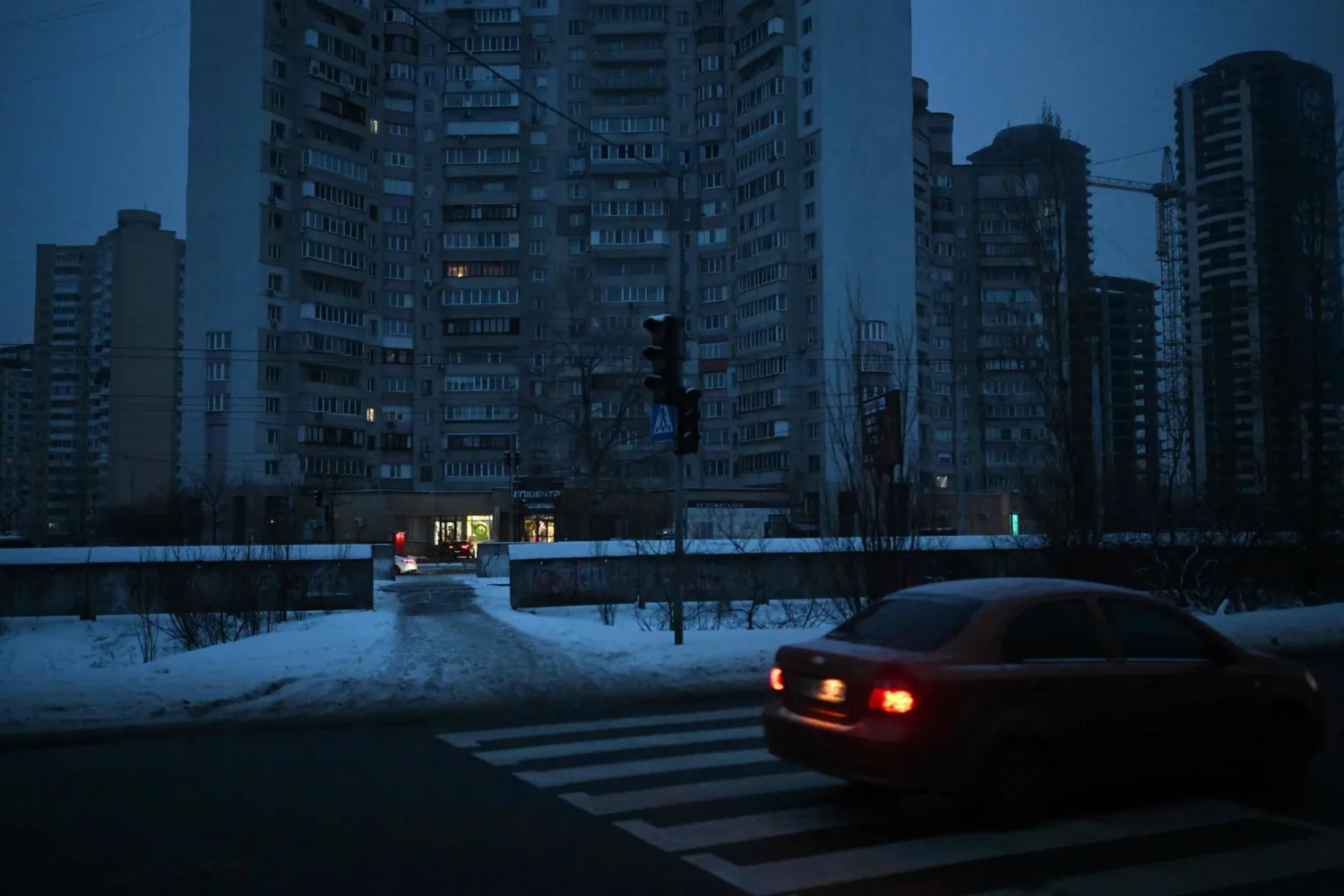 A car drives past a non-functioning traffic light in a residential area of Kyiv that has been left without electricity and water due to recent Russian strikes battering the energy sector, on January 22, 2026, amid the Russian invasion of Ukraine. (AFP)