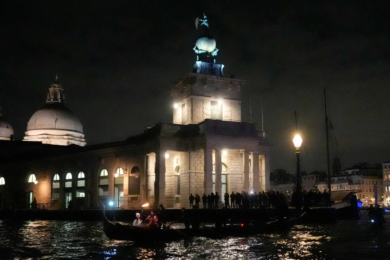 A torchbearer holds an Olympic torch flame on the Grand Canal in Venice, Italy, Thursday, Jan. 22, 2026, its journey will conclude in Milan on February 6 for the Winter Olympics opening ceremony. (AP)